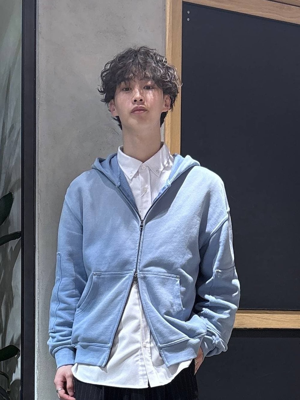 ブラック系のスラックス、ブラック系のドレスシューズ、ブルー系のパーカーを着用したメンズの冬コーディネートの2枚目の写真