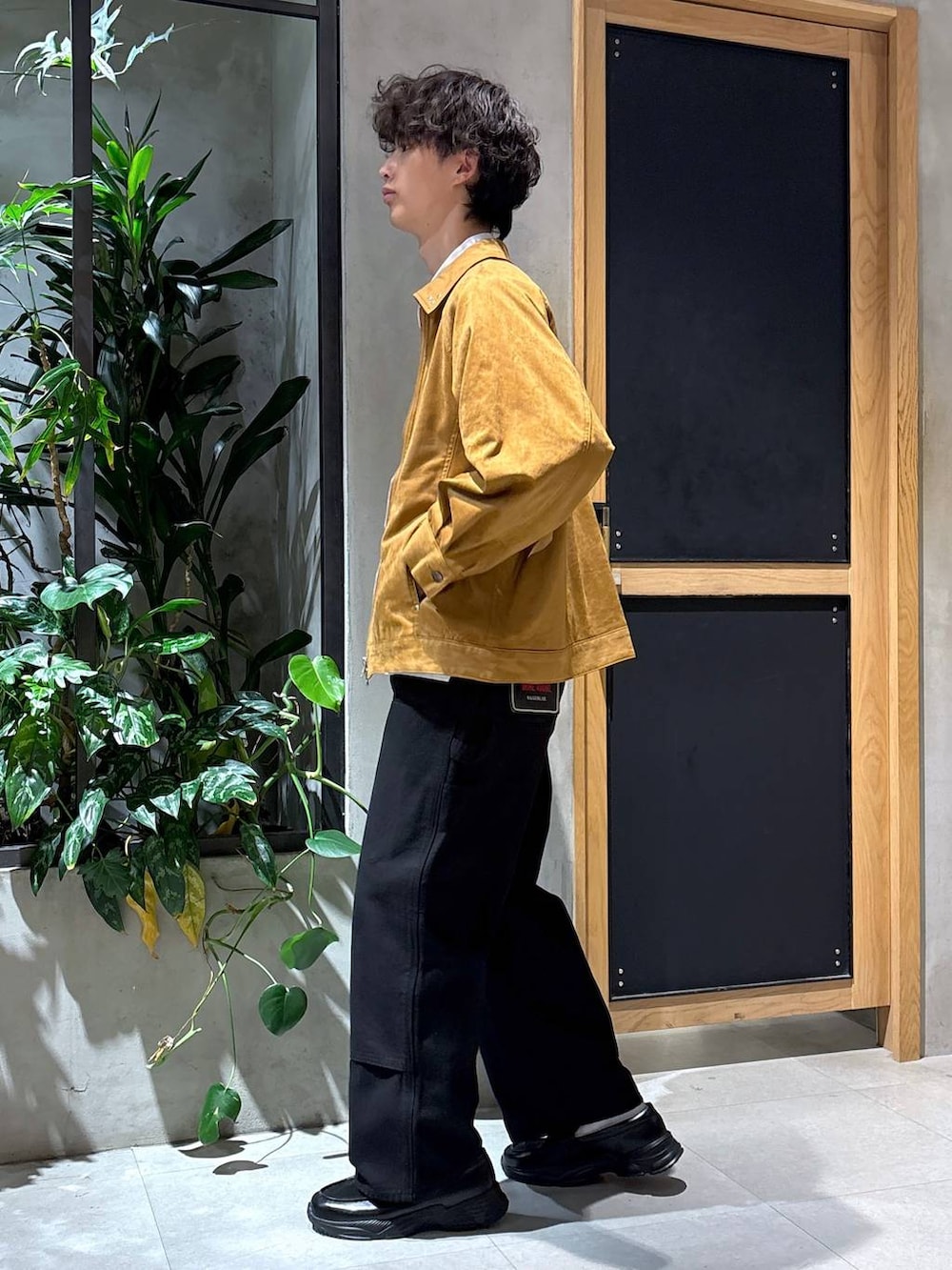 ブラック系のローファー、ブラック系のチノパンツ、ブラウン系のブルゾンを着用したメンズの秋コーディネートの7枚目の写真