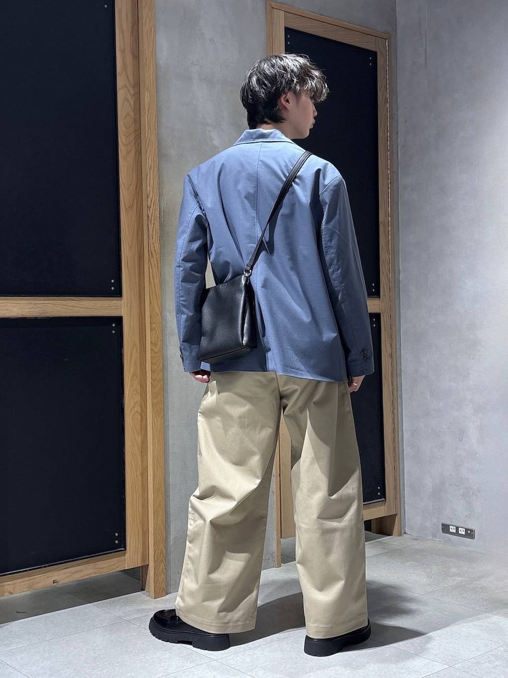 ブルー系のテーラードジャケット、ブラック系のドレスシューズ、ブラック系のショルダーバッグを着用したメンズの春コーディネートの5枚目の写真