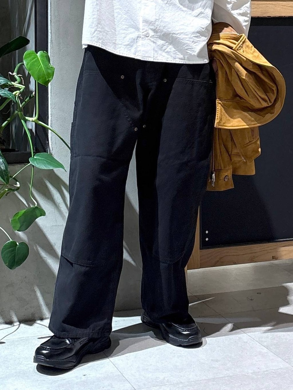 ブラック系のローファー、ブラック系のチノパンツ、ブラウン系のブルゾンを着用したメンズの秋コーディネートの2枚目の写真