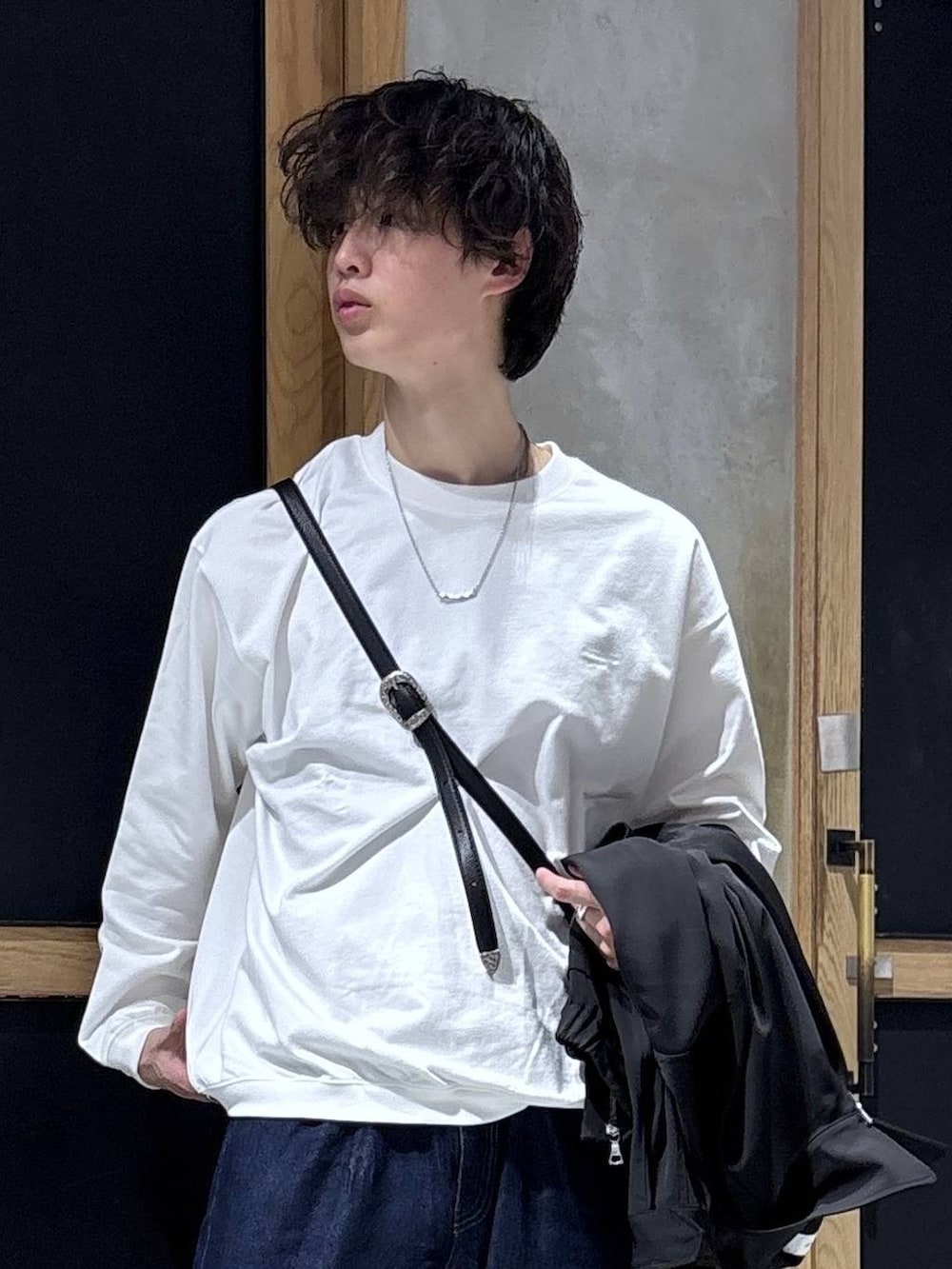 ブラック系のショルダーバッグ、ブラック系のブルゾン、ホワイト系のスウェットを着用したメンズの春コーディネートの2枚目の写真