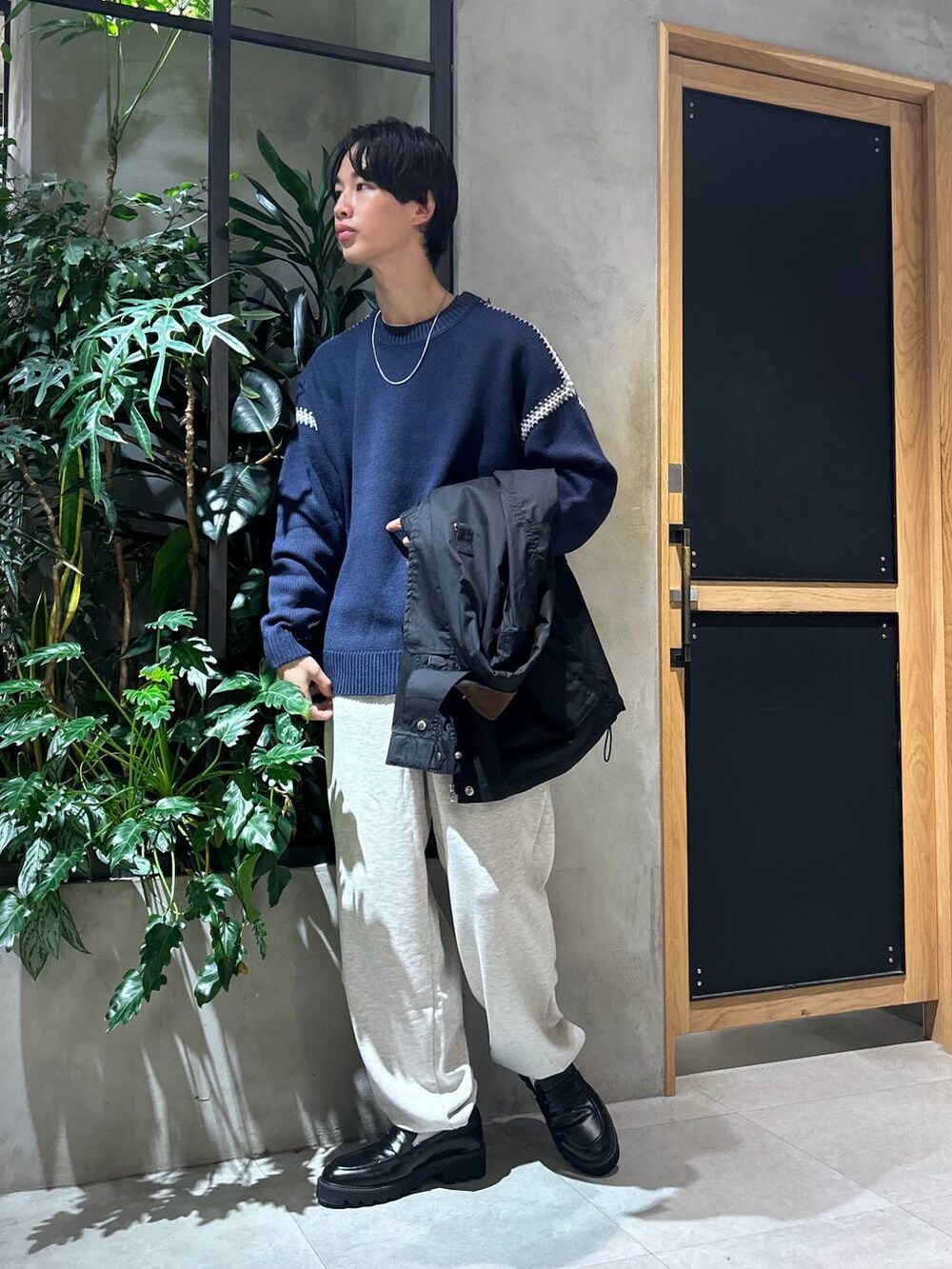 ブラック系のドレスシューズ、ブルー系のニット/セーター、ホワイト系のTシャツ/カットソーを着用したメンズの秋コーディネートの3枚目の写真