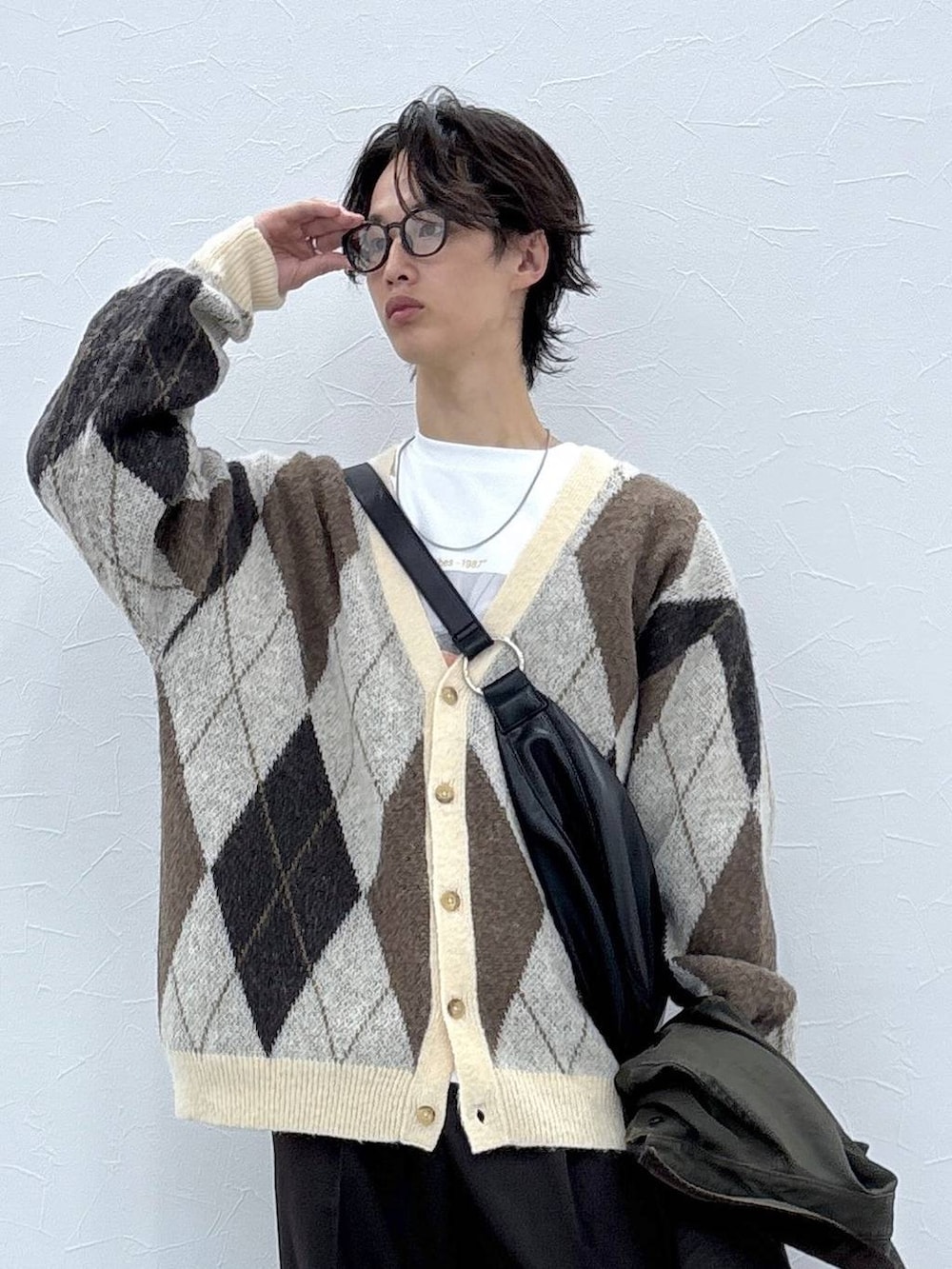 ホワイト系のカーディガン/ボレロ、ブラウン系のスラックス、グリーン系のブルゾンを着用したメンズの秋コーディネートの7枚目の写真