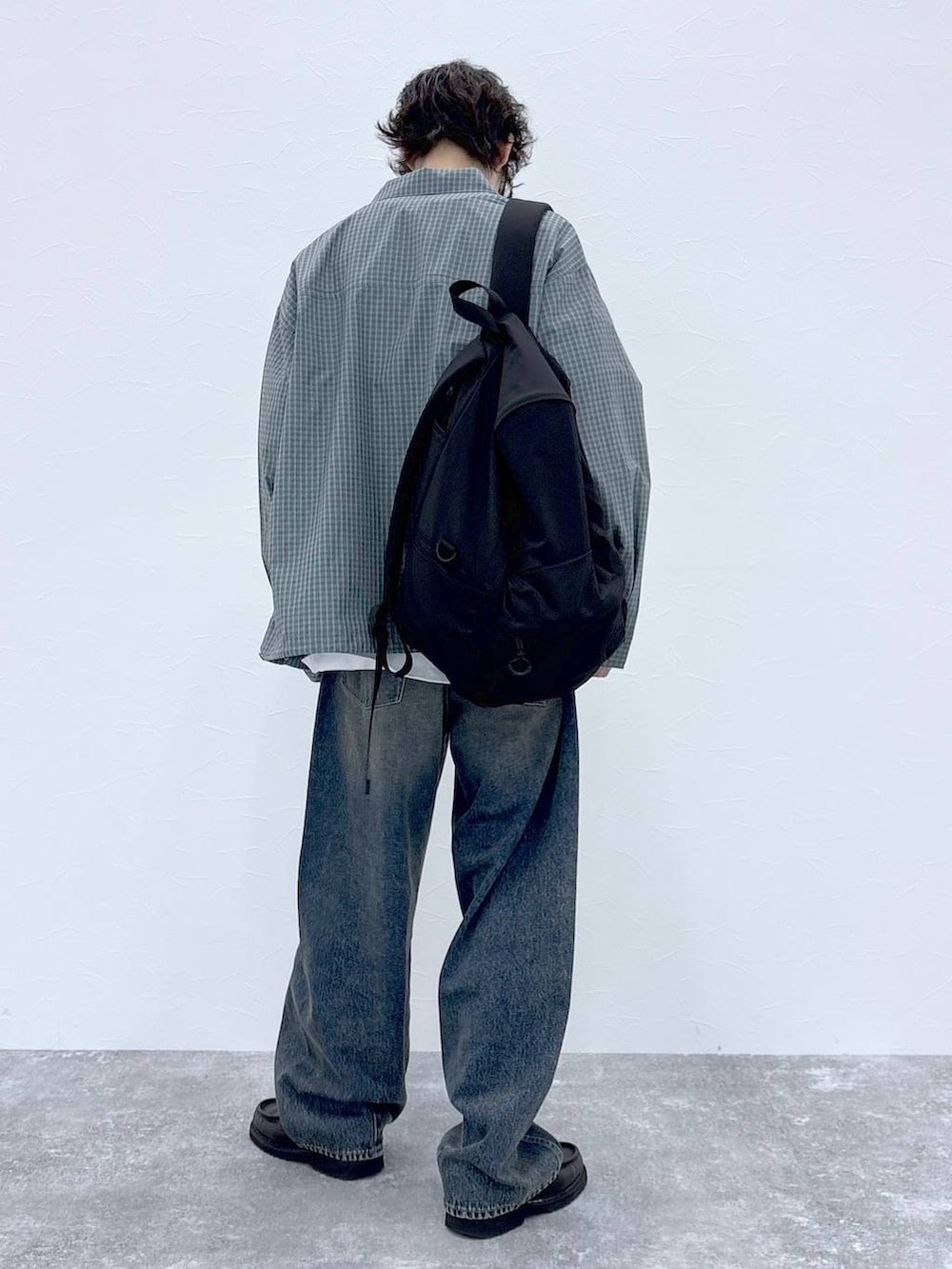 ブラック系のバックパック/リュック、ブルー系のデニムパンツ、ホワイト系のTシャツ/カットソーを着用したメンズの秋コーディネートの5枚目の写真