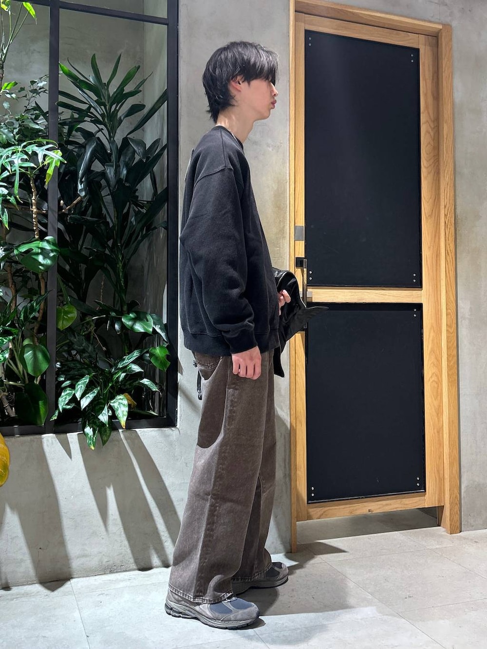 ブラウン系のデニムパンツ、ブラック系のスウェット、ブラック系のブルゾンを着用したメンズの冬コーディネートの3枚目の写真