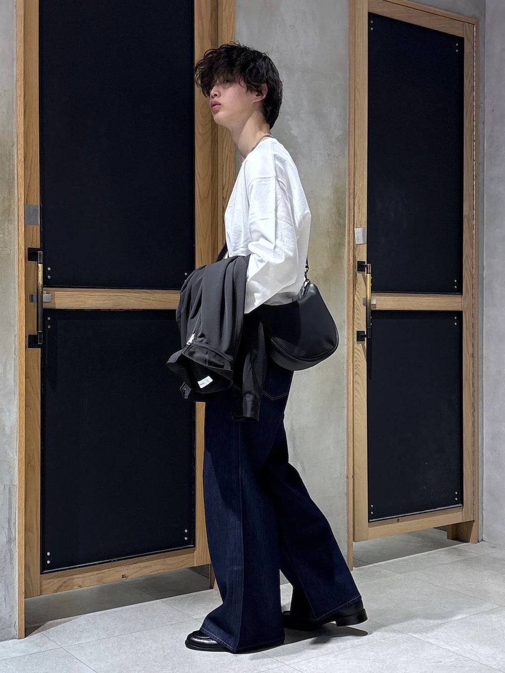 ブラック系のショルダーバッグ、ブラック系のブルゾン、ホワイト系のスウェットを着用したメンズの春コーディネートの4枚目の写真