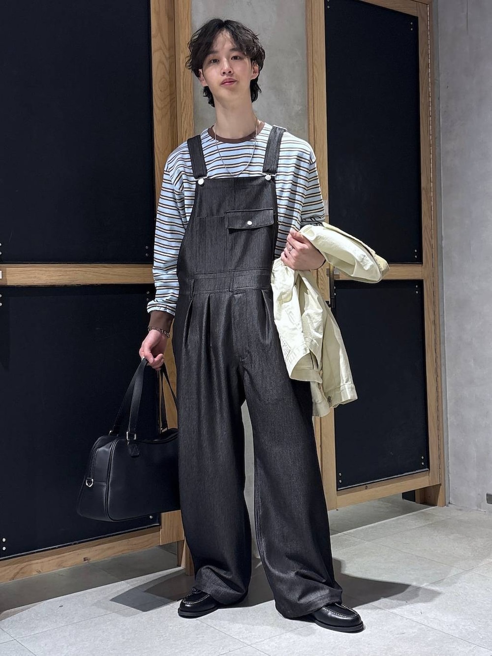 ブラック系のボストンバッグ、ブルー系のTシャツ/カットソー、ホワイト系のブルゾンを着用したメンズの春コーディネートの6枚目の写真