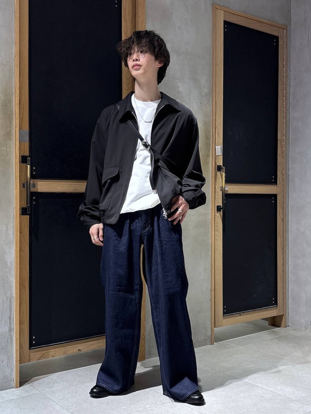 ブラック系のショルダーバッグ、ブラック系のブルゾン、ホワイト系のスウェットを着用したメンズの春コーディネートの6枚目の写真