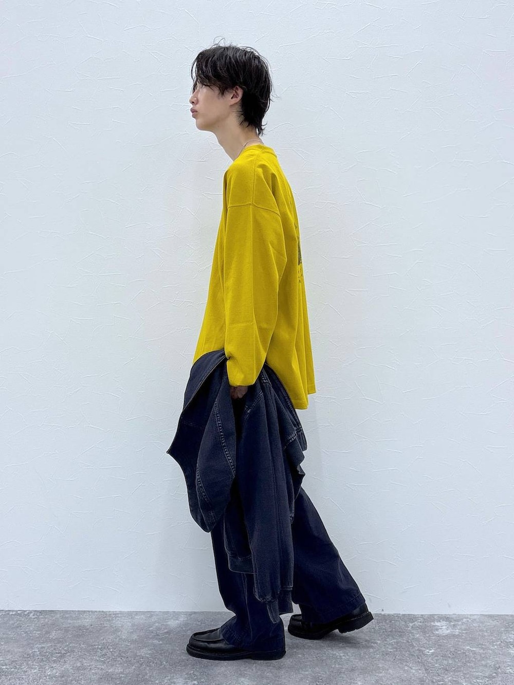 ブルー系のブルゾン、ブルー系のデニムパンツ、イエロー系のTシャツ/カットソーを着用したメンズの秋コーディネートの4枚目の写真