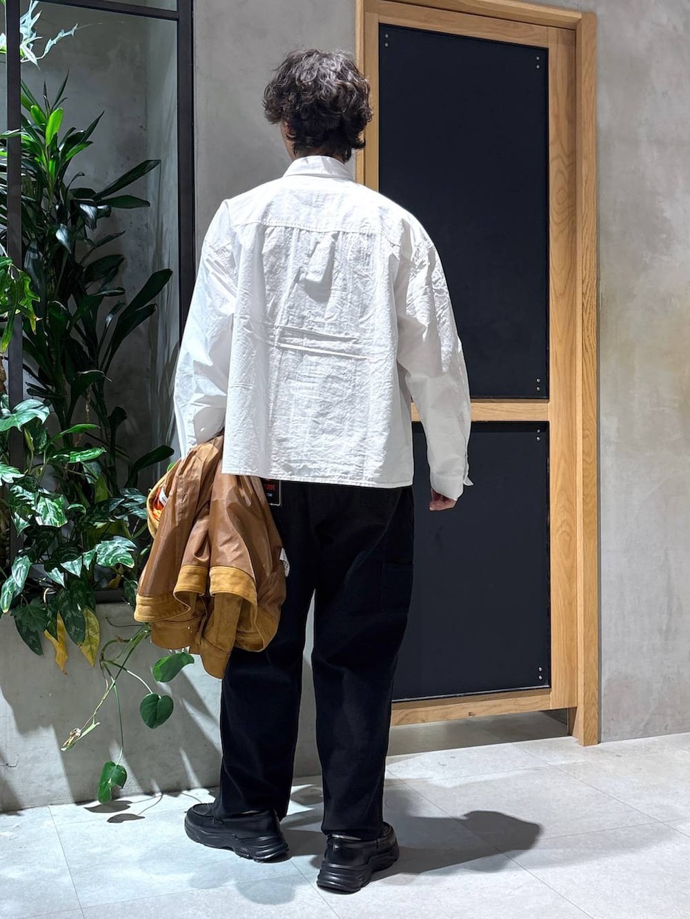 ブラック系のローファー、ブラック系のチノパンツ、ブラウン系のブルゾンを着用したメンズの秋コーディネートの4枚目の写真