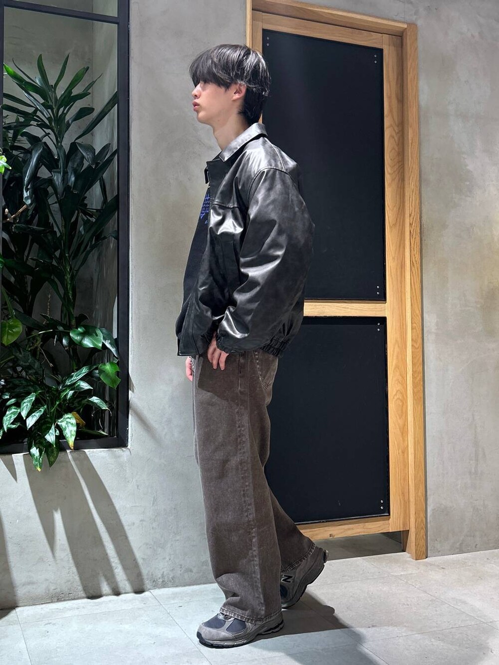 ブラウン系のデニムパンツ、ブラック系のスウェット、ブラック系のブルゾンを着用したメンズの冬コーディネートの7枚目の写真