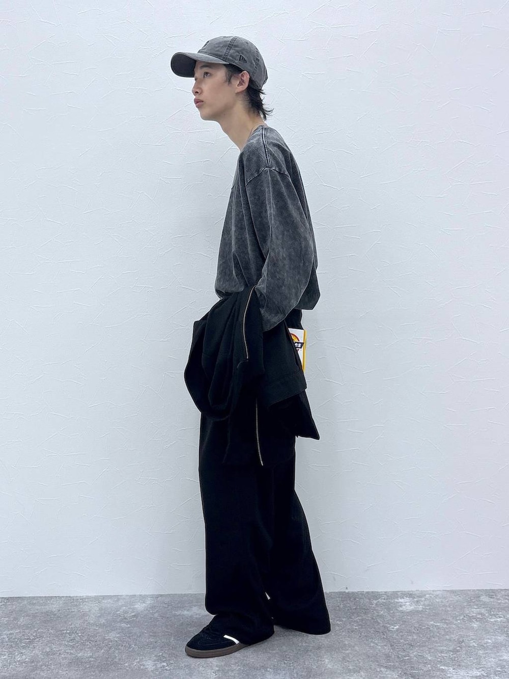 ブラック系のスニーカー、グレー系のTシャツ/カットソー、ブラック系のブルゾンを着用したメンズの秋コーディネートの4枚目の写真