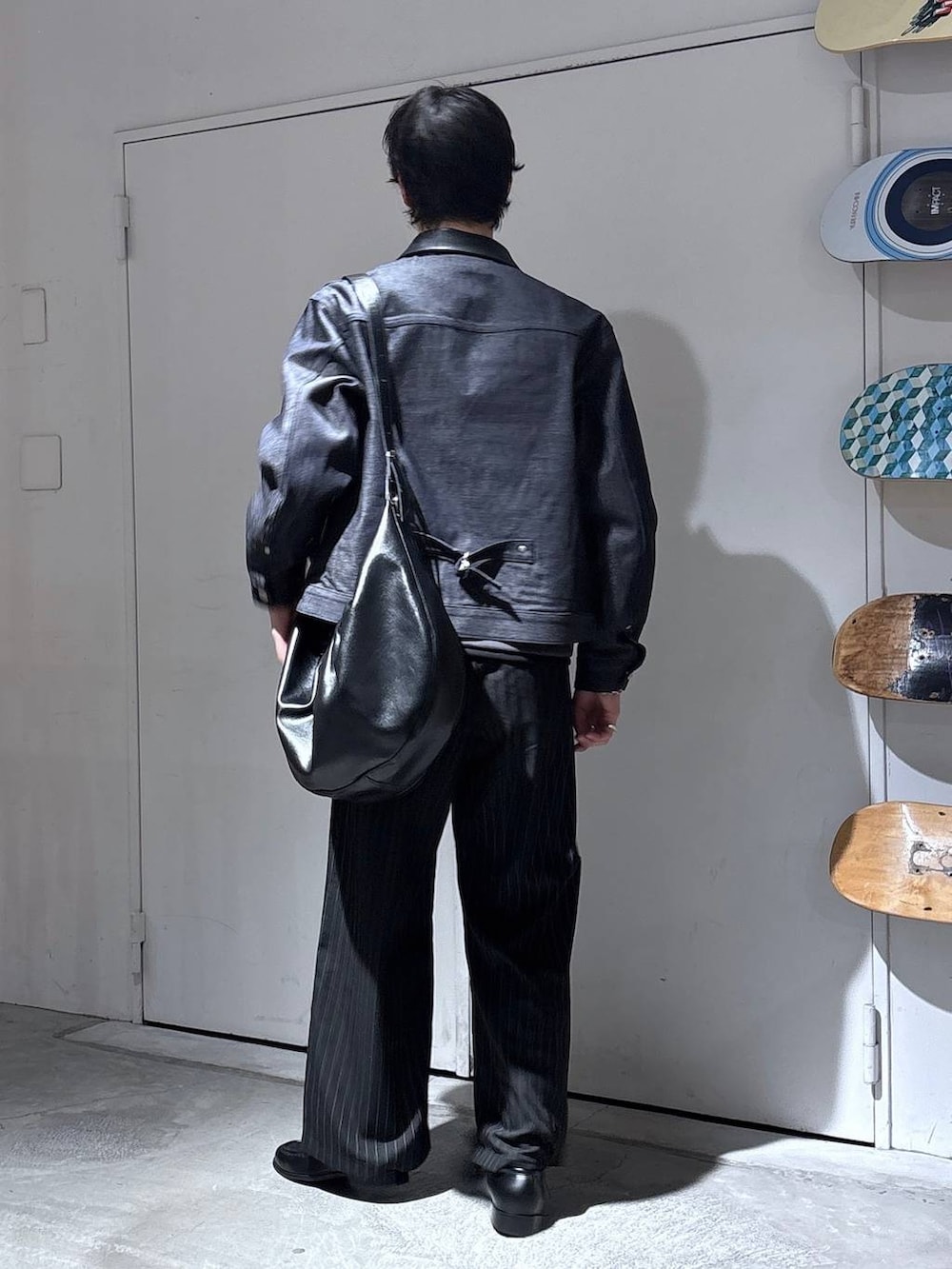 ブラック系のスラックス、ブラック系のショルダーバッグ、ブラック系のデニムジャケットを着用したメンズの秋コーディネートの5枚目の写真