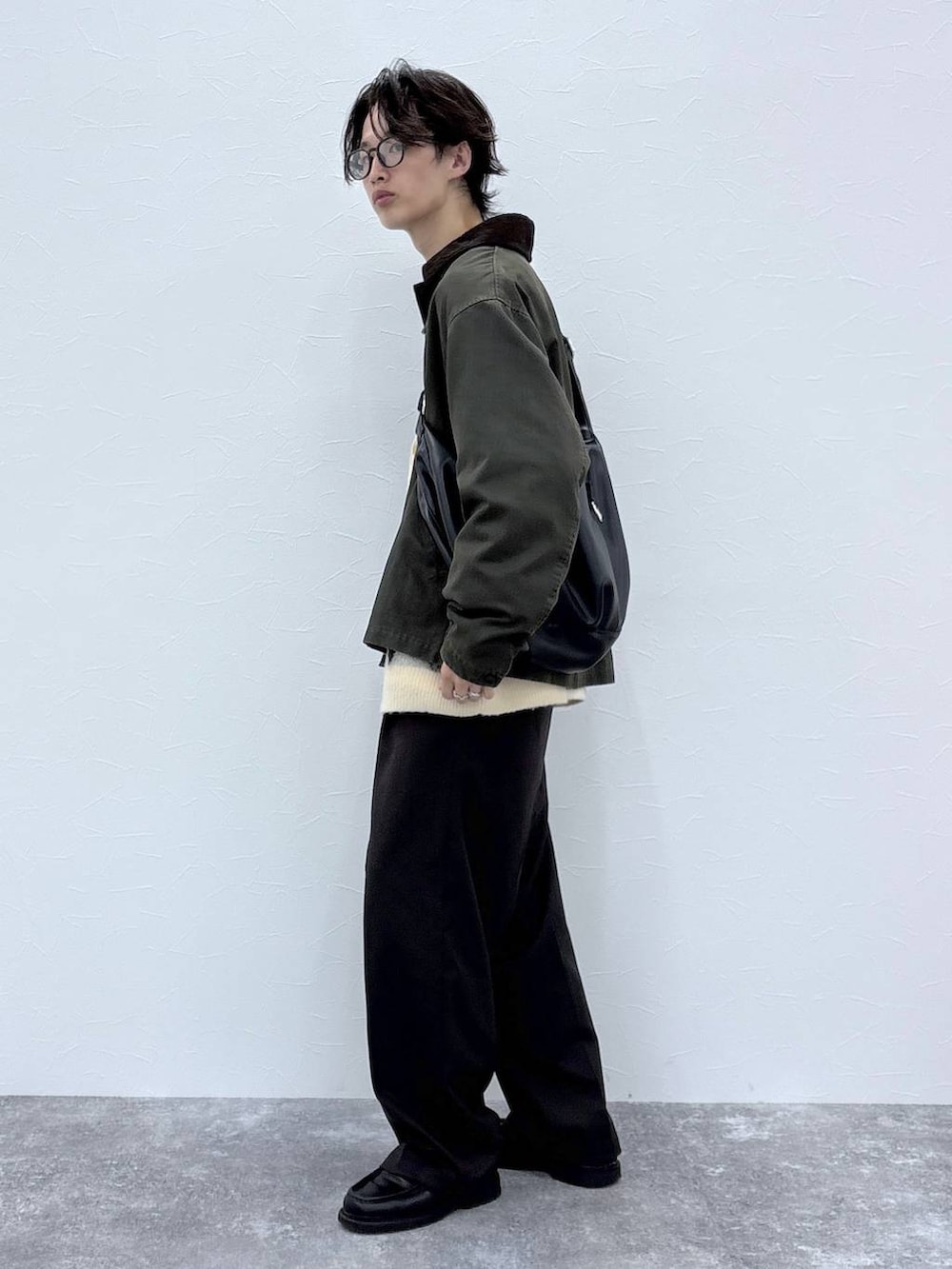 ホワイト系のカーディガン/ボレロ、ブラウン系のスラックス、グリーン系のブルゾンを着用したメンズの秋コーディネートの4枚目の写真