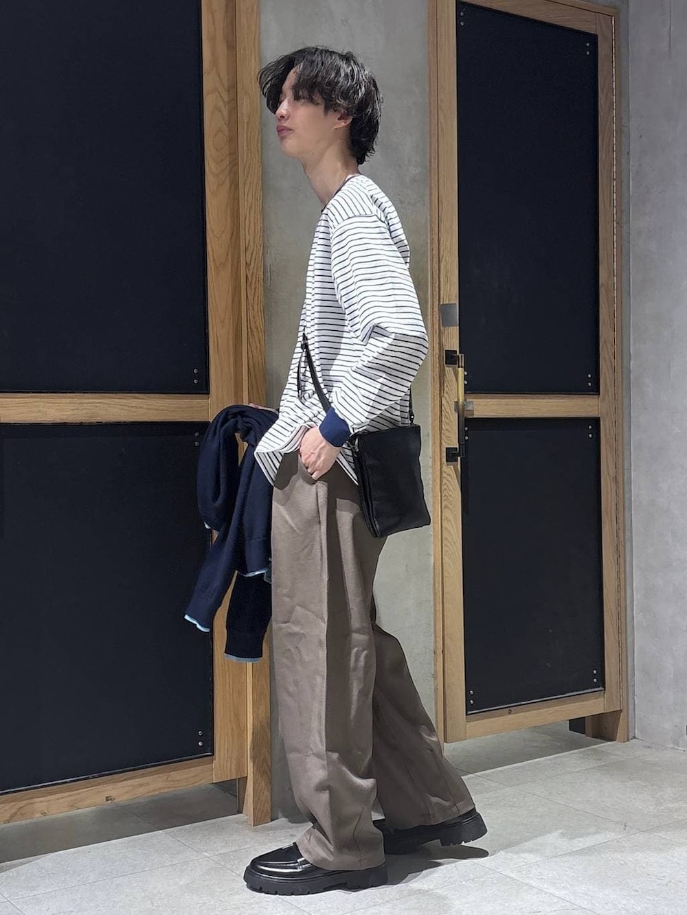 ブラック系のショルダーバッグ、ブラック系のドレスシューズ、ホワイト系のTシャツ/カットソーを着用したメンズの春コーディネートの8枚目の写真