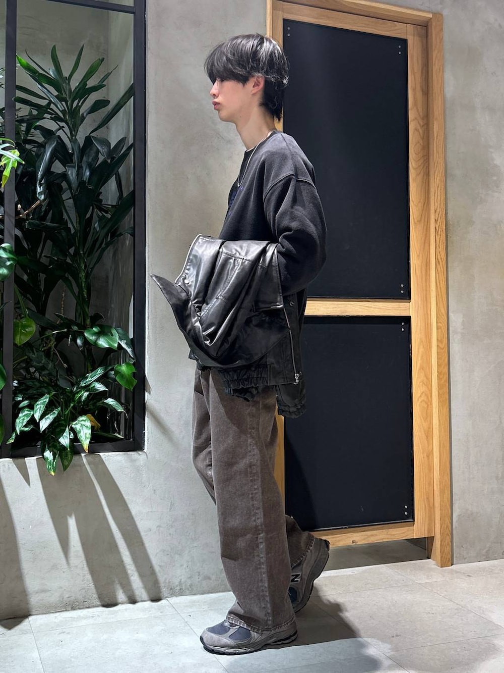 ブラウン系のデニムパンツ、ブラック系のスウェット、ブラック系のブルゾンを着用したメンズの冬コーディネートの2枚目の写真