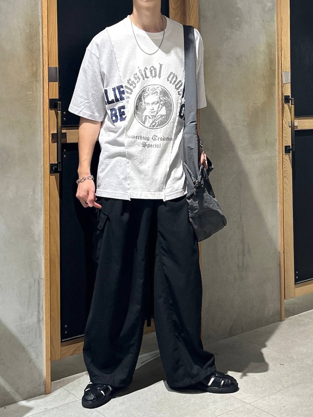 ブラック系のサンダル、ホワイト系のTシャツ/カットソー、ブラック系のカーゴパンツを着用したメンズの夏コーディネートの2枚目の写真