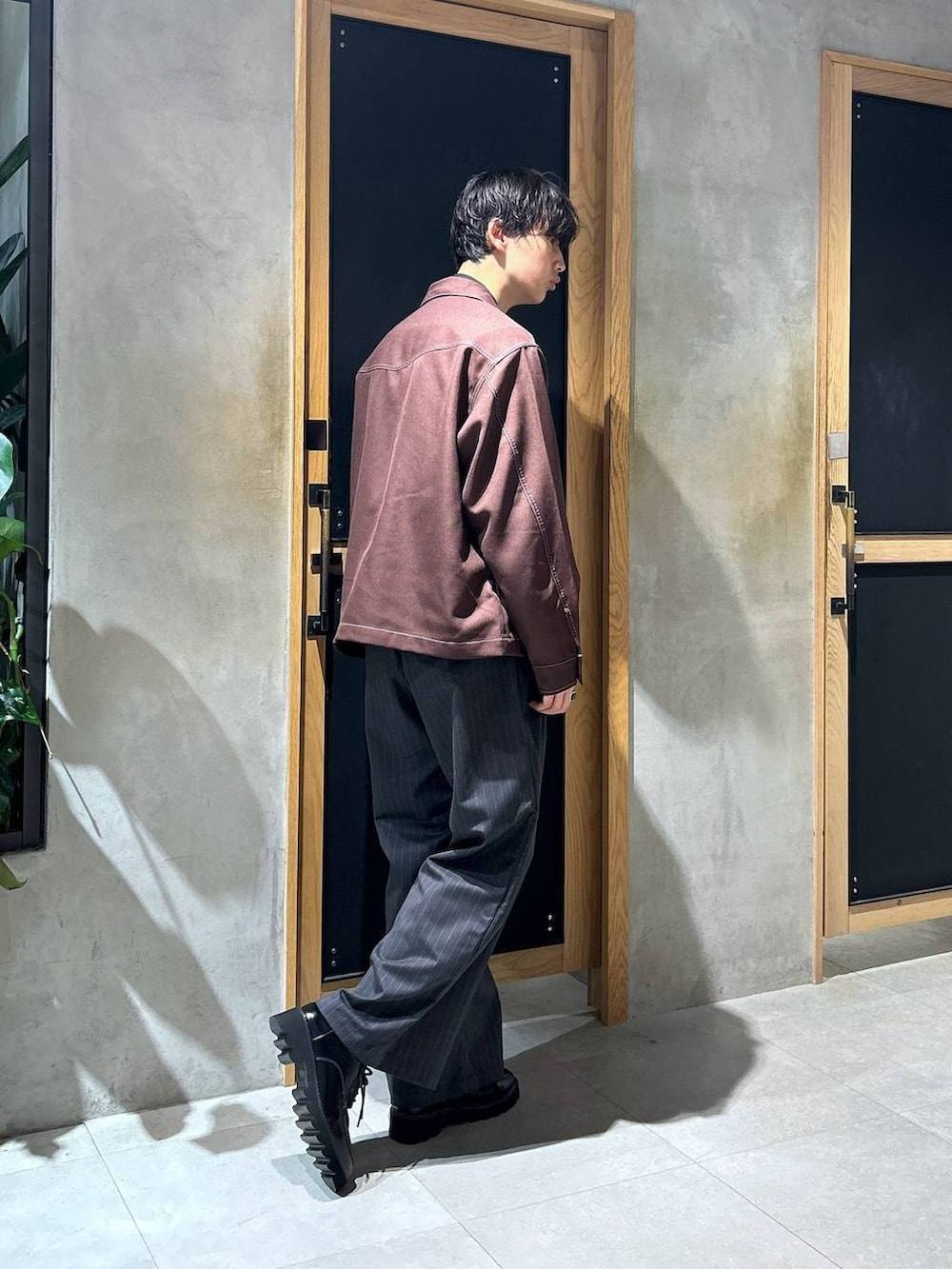 グレー系のスラックス、ブラウン系のブルゾン、ブラック系のショルダーバッグを着用したメンズの秋コーディネートの4枚目の写真