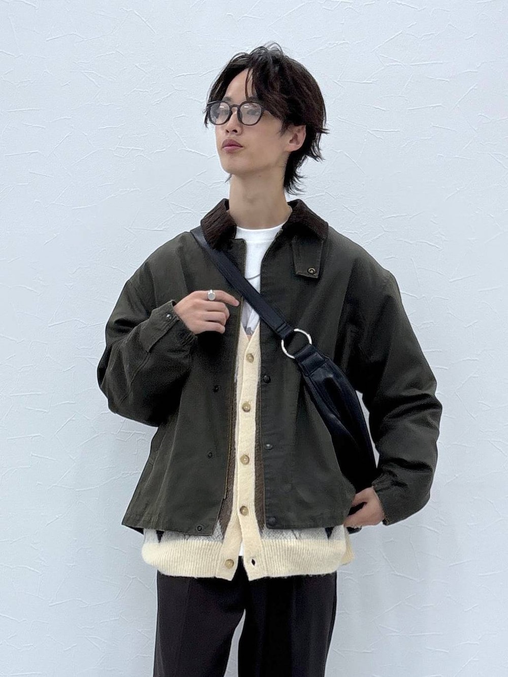 ホワイト系のカーディガン/ボレロ、ブラウン系のスラックス、グリーン系のブルゾンを着用したメンズの秋コーディネートの2枚目の写真