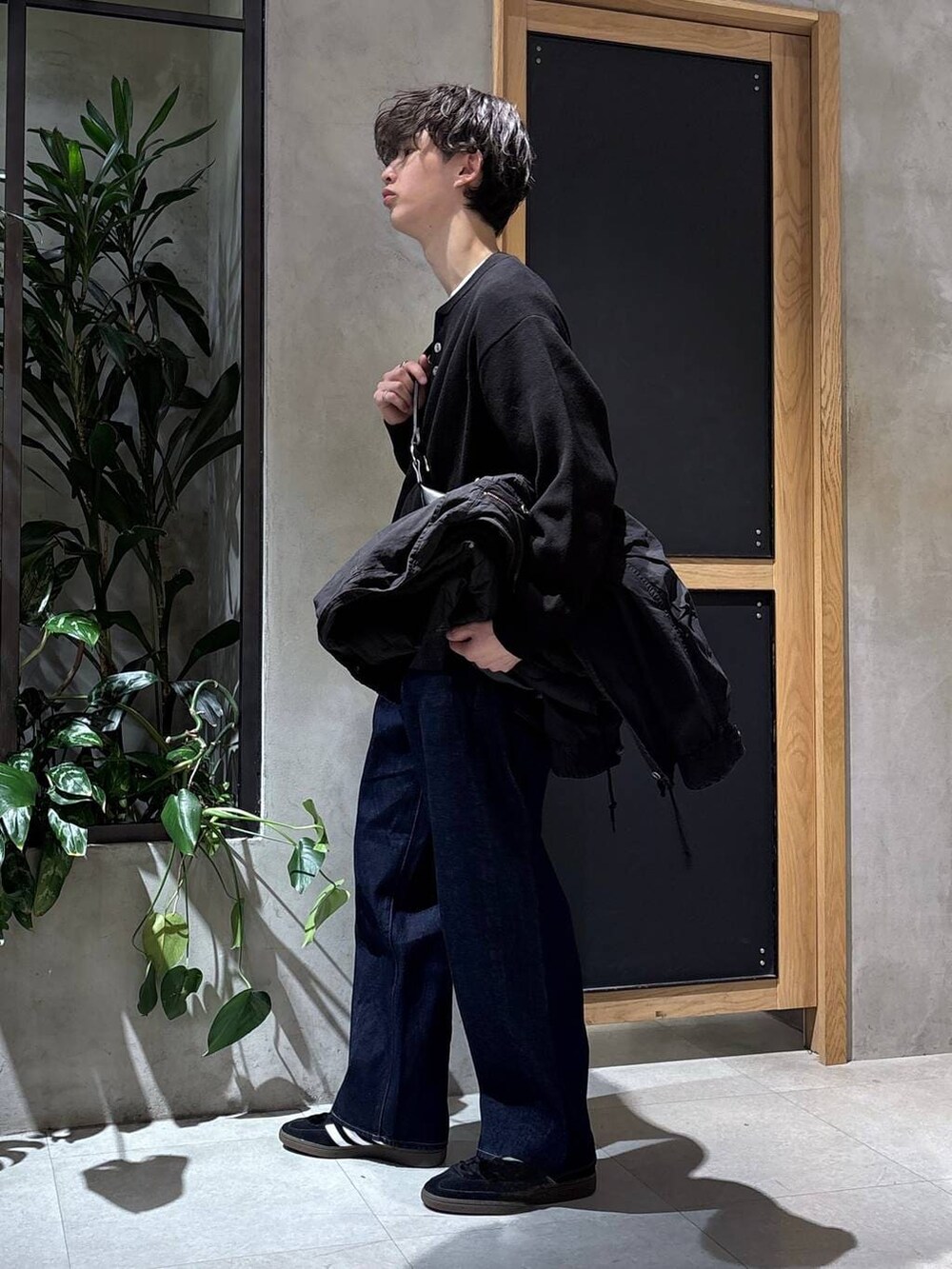 ブラック系のスニーカー、ブラック系のモッズコート、ブラック系のニット/セーターを着用したメンズの冬コーディネートの8枚目の写真