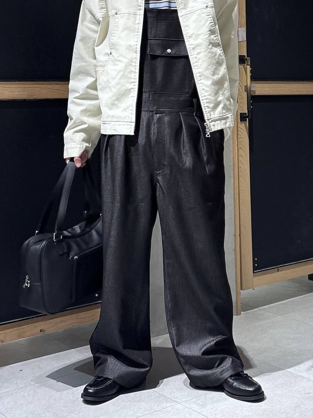 ブラック系のボストンバッグ、ブルー系のTシャツ/カットソー、ホワイト系のブルゾンを着用したメンズの春コーディネートの3枚目の写真