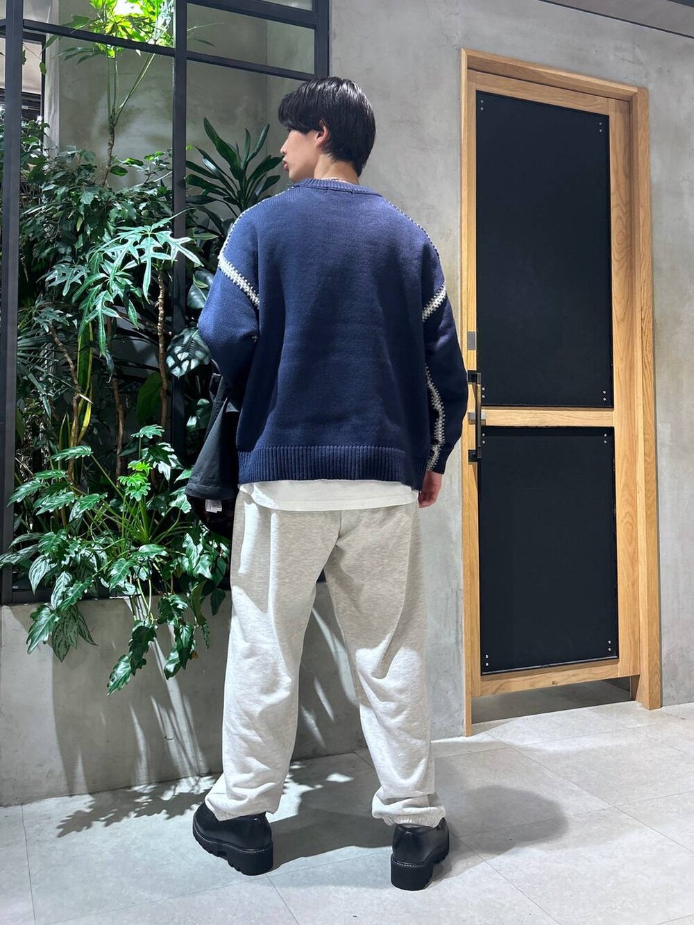 ブラック系のドレスシューズ、ブルー系のニット/セーター、ホワイト系のTシャツ/カットソーを着用したメンズの秋コーディネートの5枚目の写真