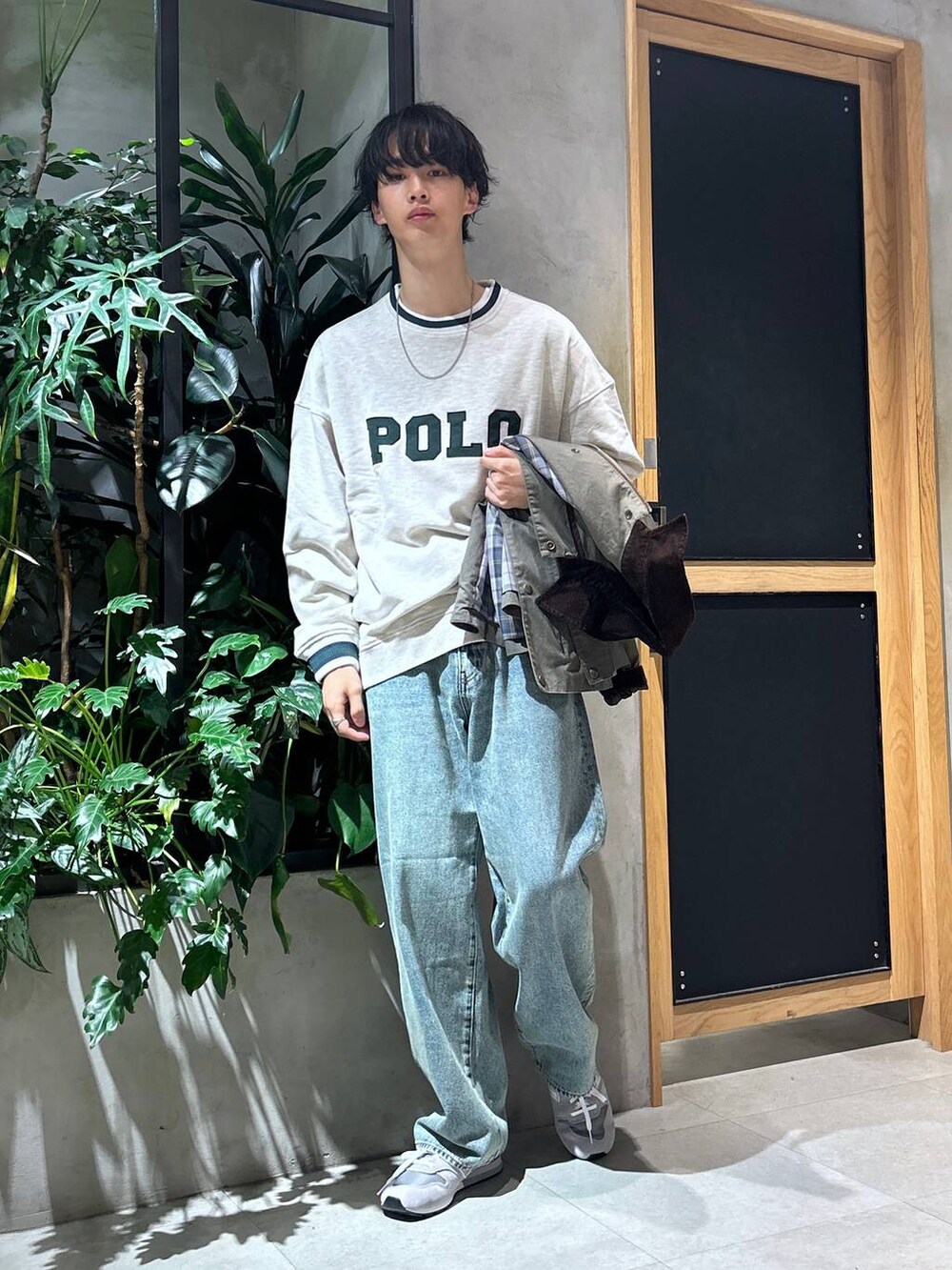グレー系のスニーカー、ブルー系のデニムパンツ、グリーン系のブルゾンを着用したメンズの秋コーディネートの6枚目の写真