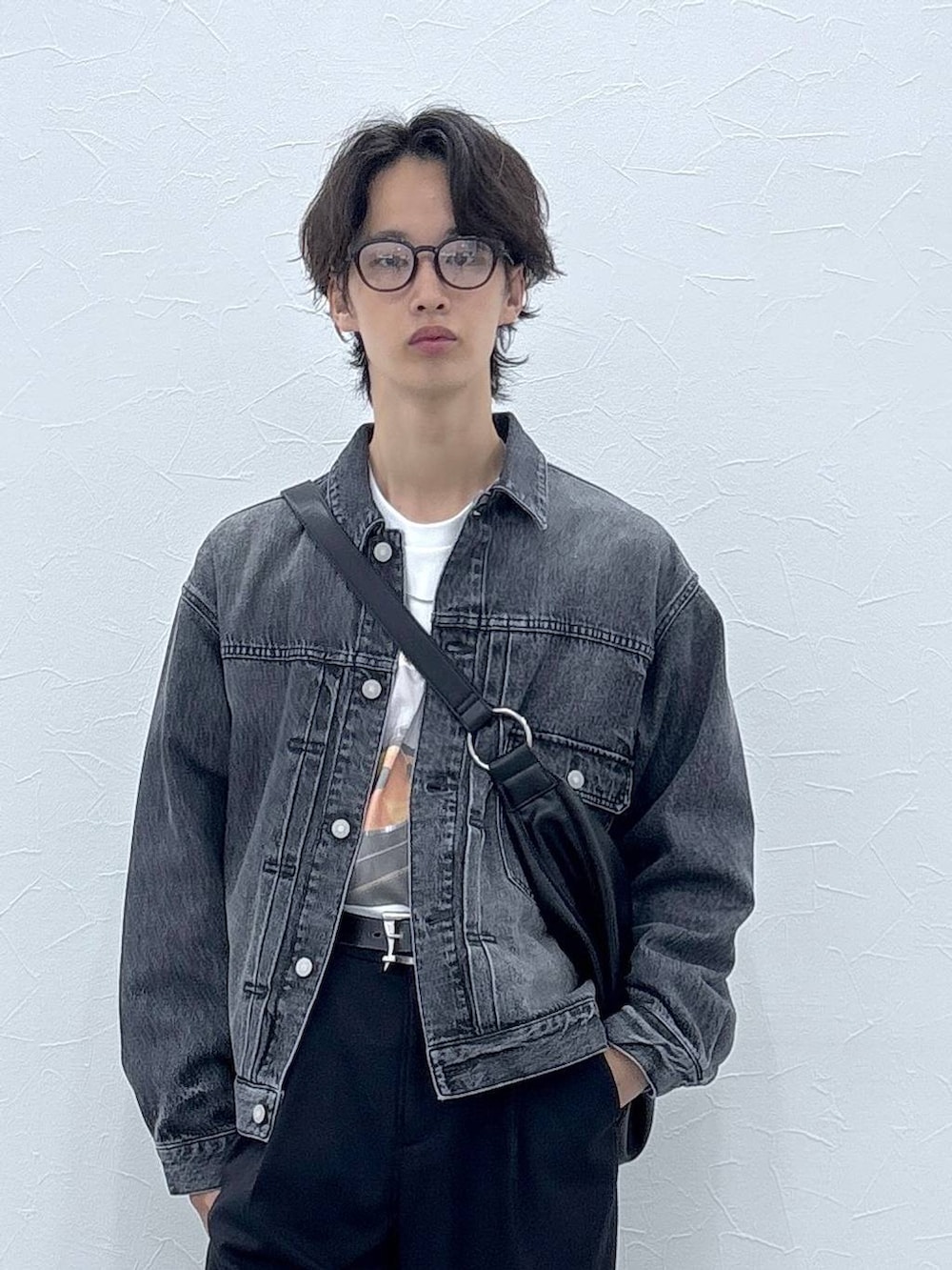 ブラック系のスラックス、グレー系のデニムジャケット、その他のショルダーバッグを着用したメンズの秋コーディネートの7枚目の写真