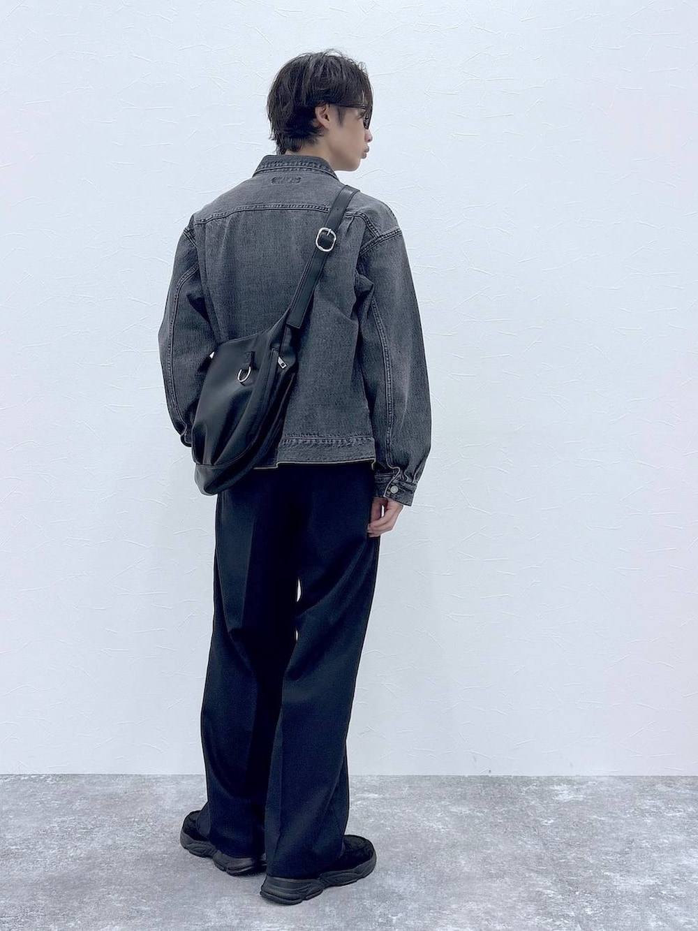 ブラック系のスラックス、グレー系のデニムジャケット、その他のショルダーバッグを着用したメンズの秋コーディネートの9枚目の写真