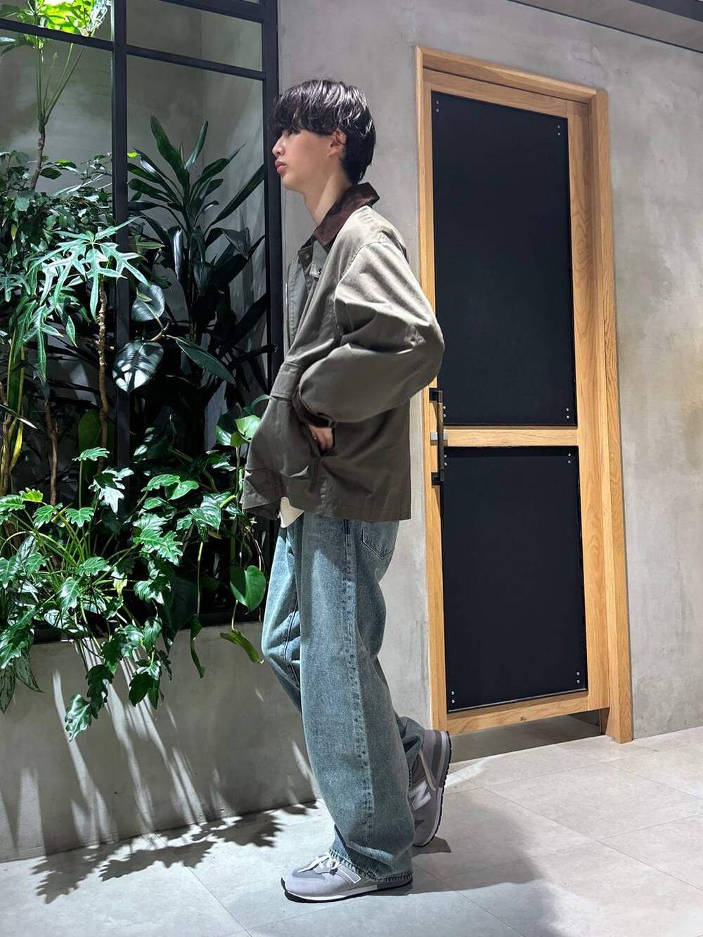 グレー系のスニーカー、ブルー系のデニムパンツ、グリーン系のブルゾンを着用したメンズの秋コーディネートの6枚目の写真