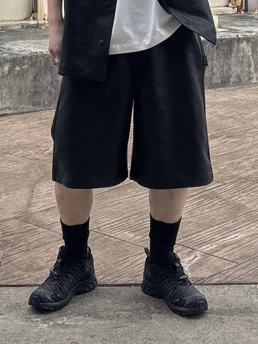 ブラック系のスニーカー、ホワイト系のTシャツ/カットソー、ブラック系のシャツ/ブラウスを着用したメンズの春コーディネートの3枚目の写真