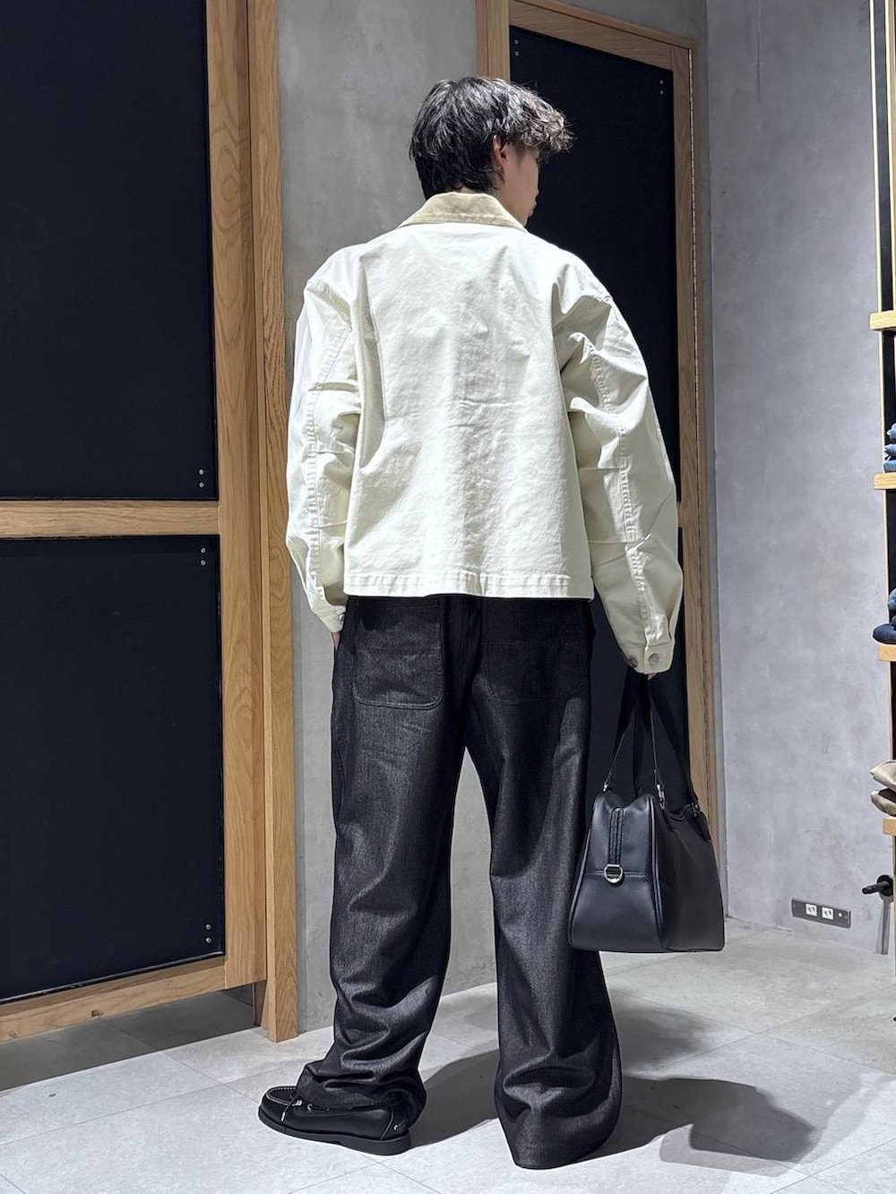 ブラック系のボストンバッグ、ブルー系のTシャツ/カットソー、ホワイト系のブルゾンを着用したメンズの春コーディネートの5枚目の写真