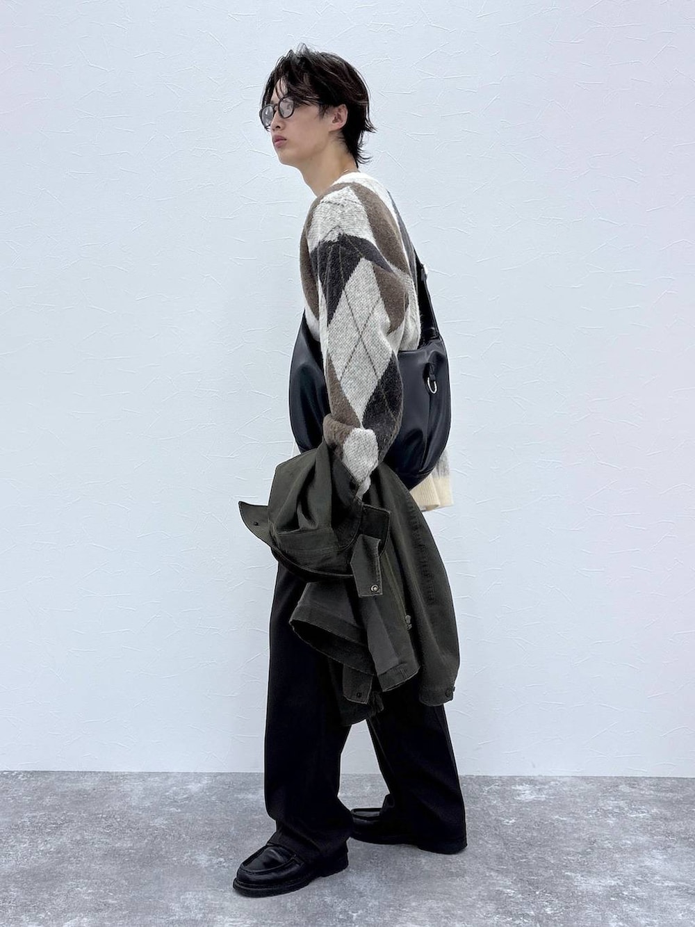 ホワイト系のカーディガン/ボレロ、ブラウン系のスラックス、グリーン系のブルゾンを着用したメンズの秋コーディネートの8枚目の写真