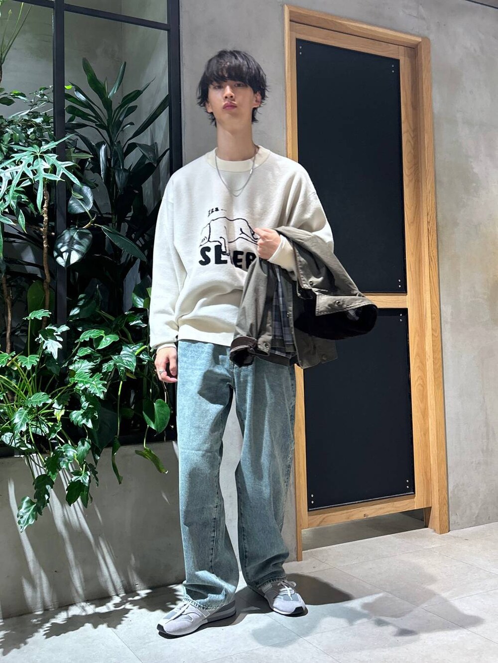 グレー系のスニーカー、ブルー系のデニムパンツ、グリーン系のブルゾンを着用したメンズの秋コーディネートの3枚目の写真