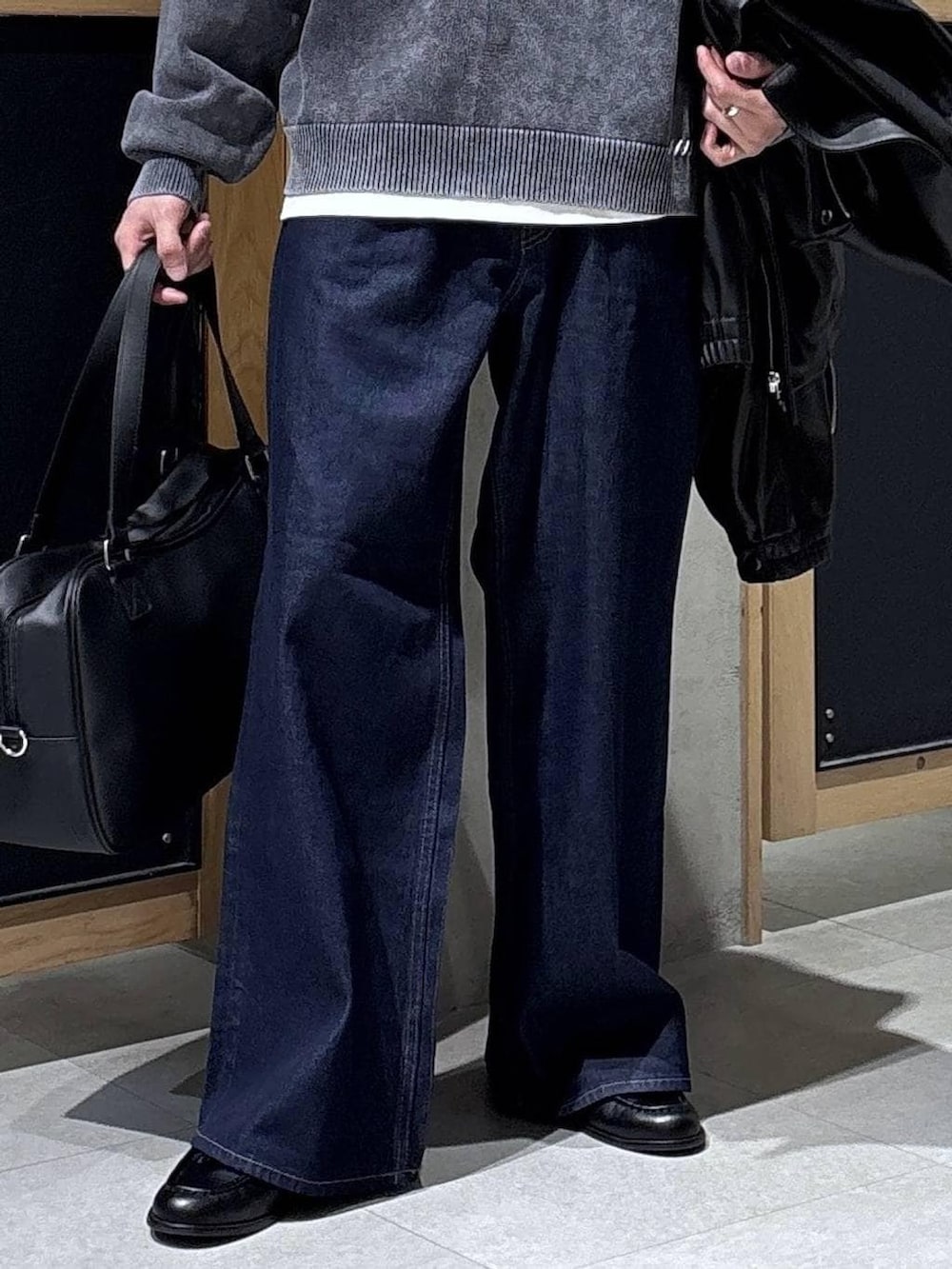 グレー系のニット/セーター、ホワイト系のTシャツ/カットソー、ブラック系のボストンバッグを着用したメンズの春コーディネートの3枚目の写真