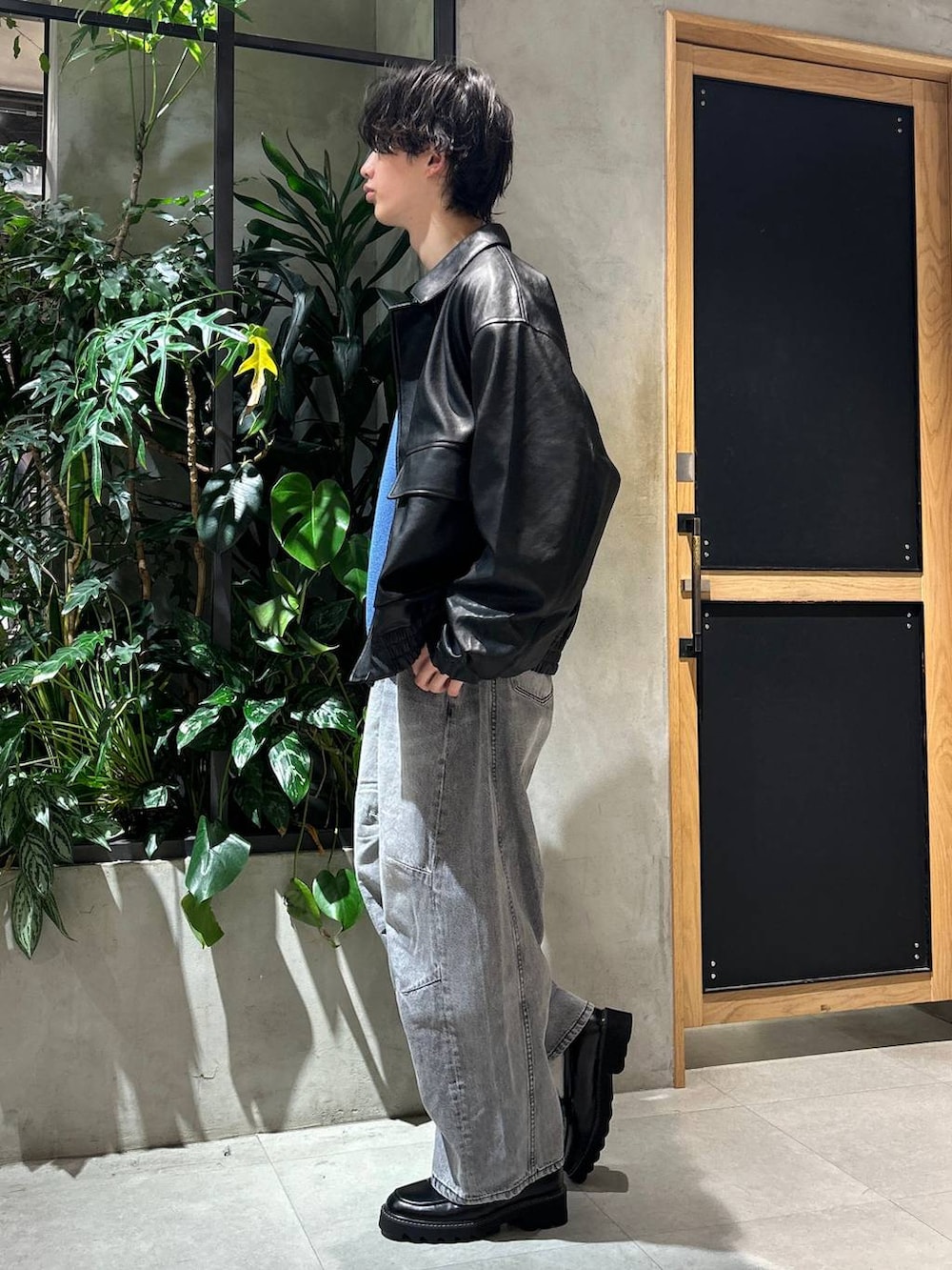 グレー系のブルゾン、ブラック系のドレスシューズ、グレー系のデニムパンツを着用したメンズの冬コーディネートの4枚目の写真