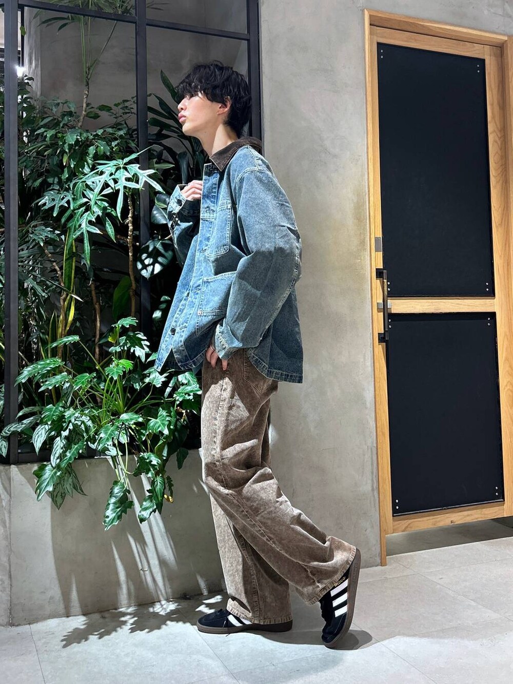 ブラック系のスニーカー、ブルー系のデニムジャケット、ホワイト系のTシャツ/カットソーを着用したメンズの秋コーディネートの4枚目の写真