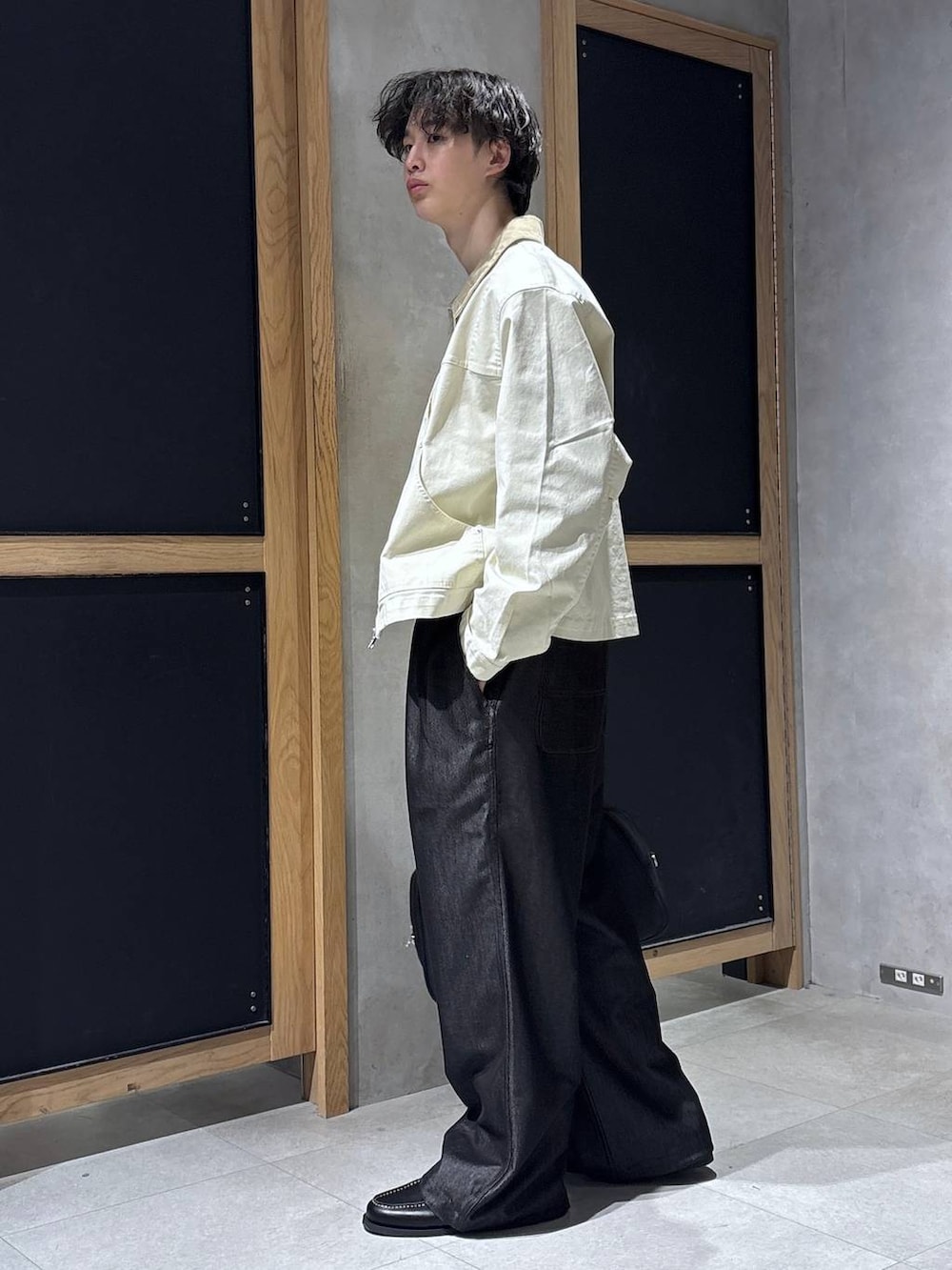 ブラック系のボストンバッグ、ブルー系のTシャツ/カットソー、ホワイト系のブルゾンを着用したメンズの春コーディネートの4枚目の写真