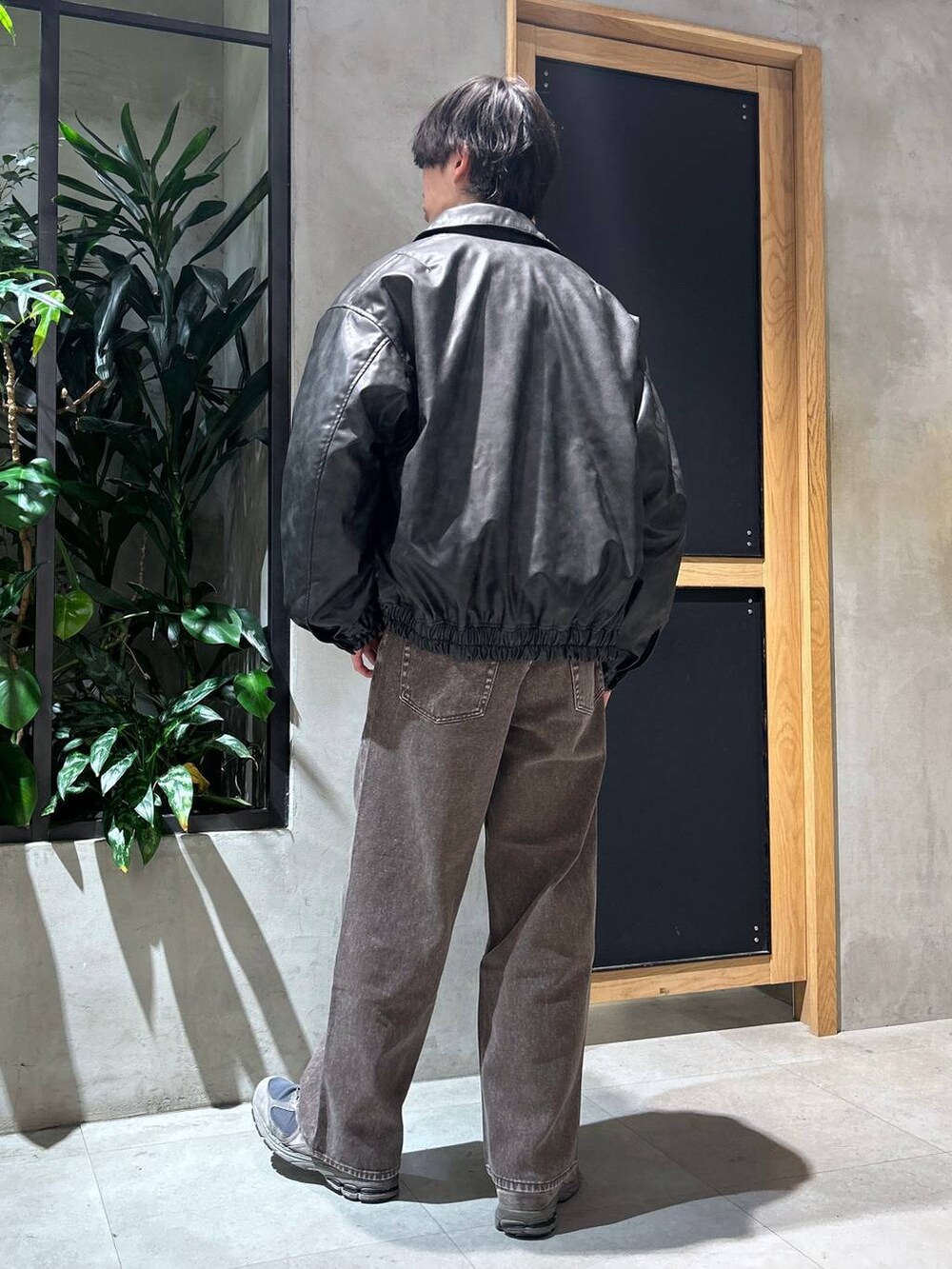 ブラウン系のデニムパンツ、ブラック系のスウェット、ブラック系のブルゾンを着用したメンズの冬コーディネートの8枚目の写真