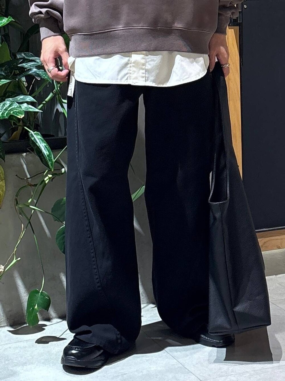 ブラック系のローファー、ブラック系のトートバッグ、ブラック系のデニムパンツを着用したメンズの秋コーディネートの3枚目の写真