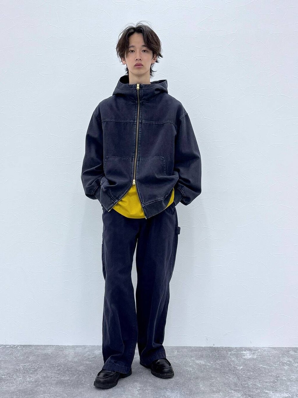 ブルー系のブルゾン、ブルー系のデニムパンツ、イエロー系のTシャツ/カットソーを着用したメンズの秋コーディネートの6枚目の写真