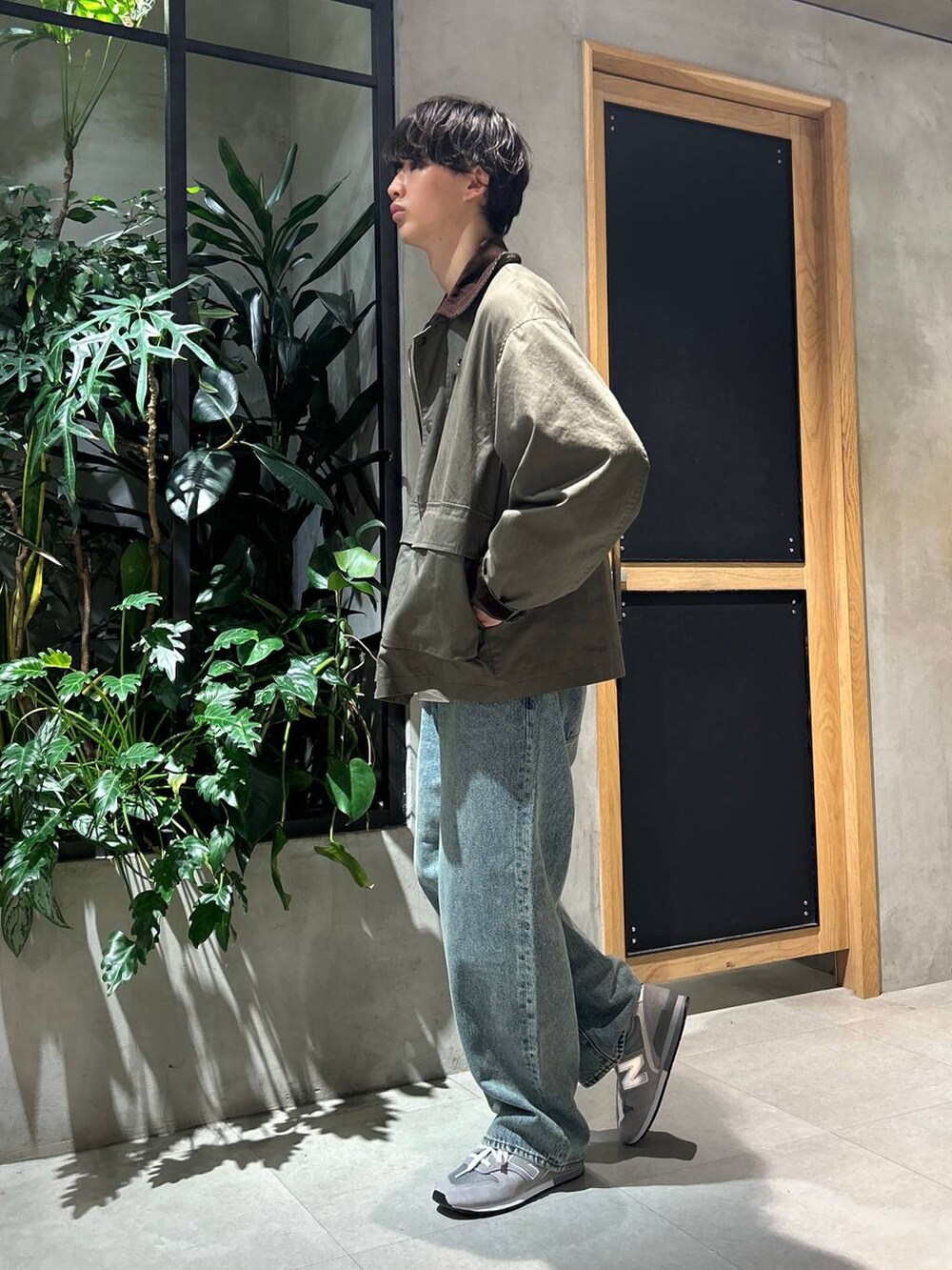 グレー系のスニーカー、ブルー系のデニムパンツ、グリーン系のブルゾンを着用したメンズの秋コーディネートの4枚目の写真