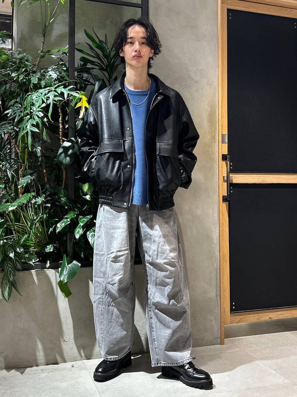 グレー系のブルゾン、ブラック系のドレスシューズ、グレー系のデニムパンツを着用したメンズの冬コーディネートの2枚目の写真