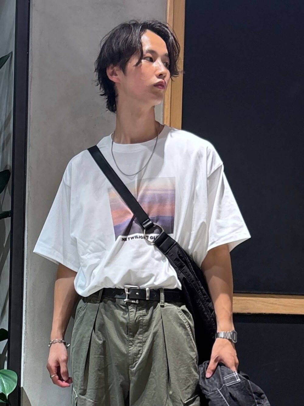 グリーン系のカーゴパンツ、ブラック系のサンダル、ブラック系のシャツ/ブラウスを着用したメンズの夏コーディネートの2枚目の写真