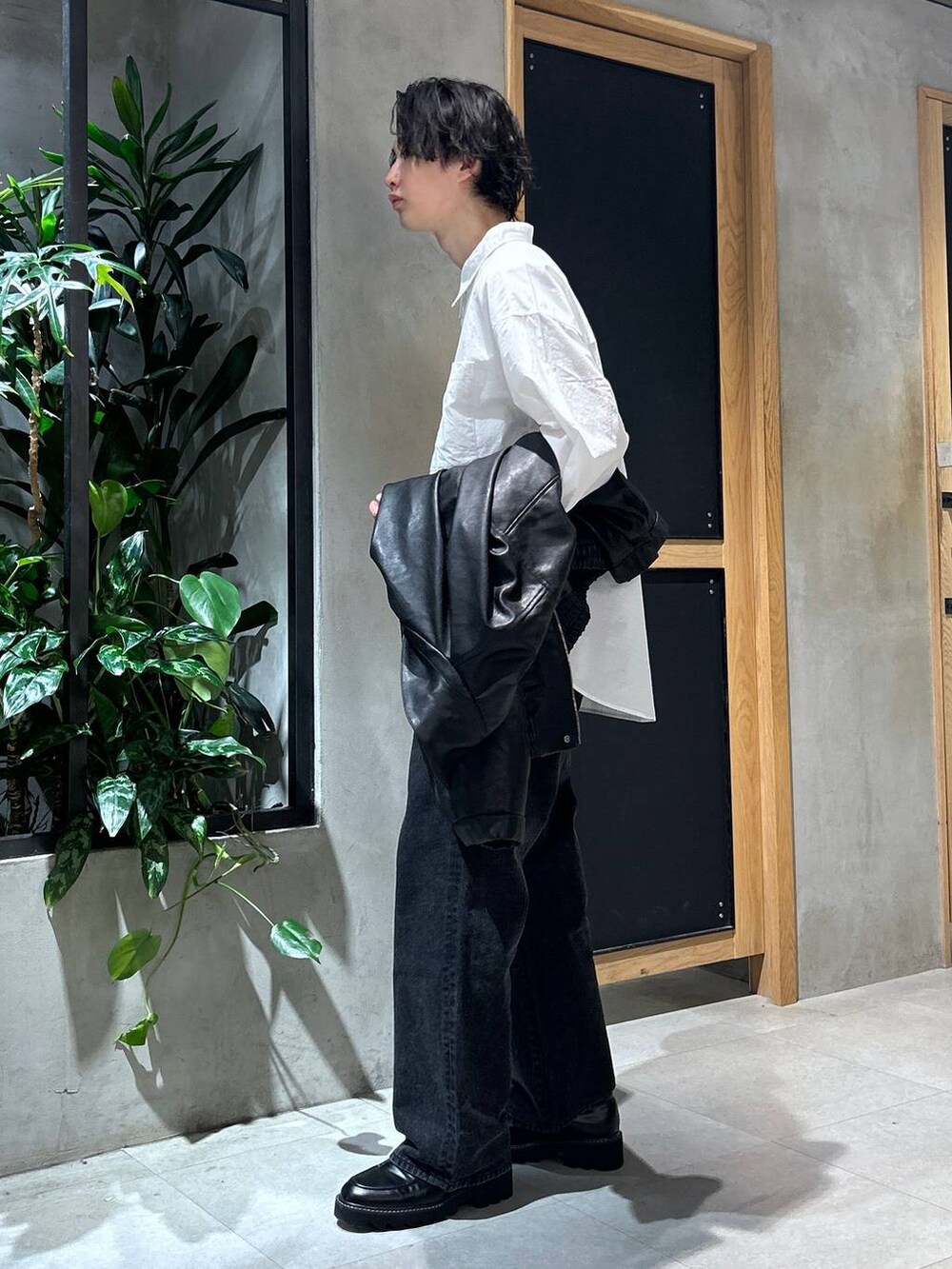ブラック系のブルゾン、ブラック系のドレスシューズ、ブラック系のデニムパンツを着用したメンズの春コーディネートの8枚目の写真