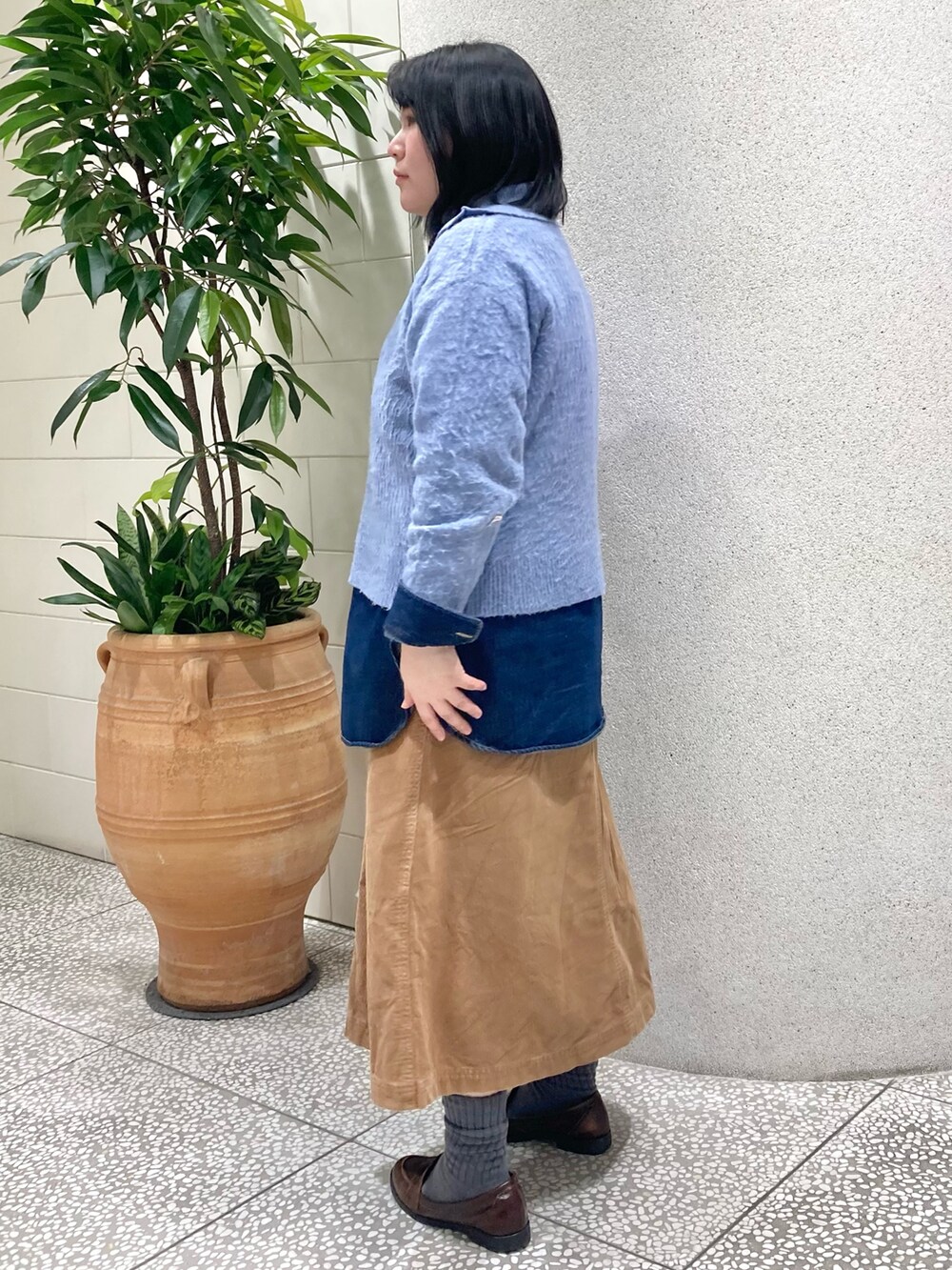 ブルー系のニット/セーター、シルバー系のトートバッグを着用したレディースの冬コーディネートの4枚目の写真