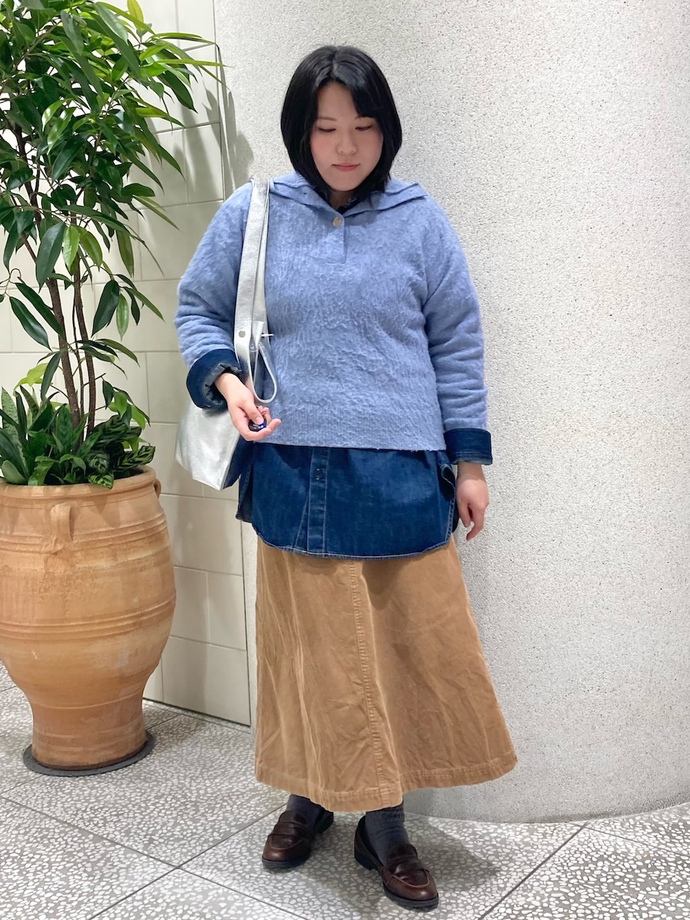 ブルー系のニット/セーター、シルバー系のトートバッグを着用したレディースの冬コーディネートの6枚目の写真