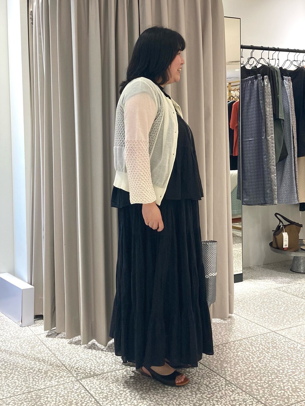 ブラック系のシャツ/ブラウス、シルバー系のかごバッグ、ブラック系のサンダルを着用したレディースの夏コーディネートの4枚目の写真