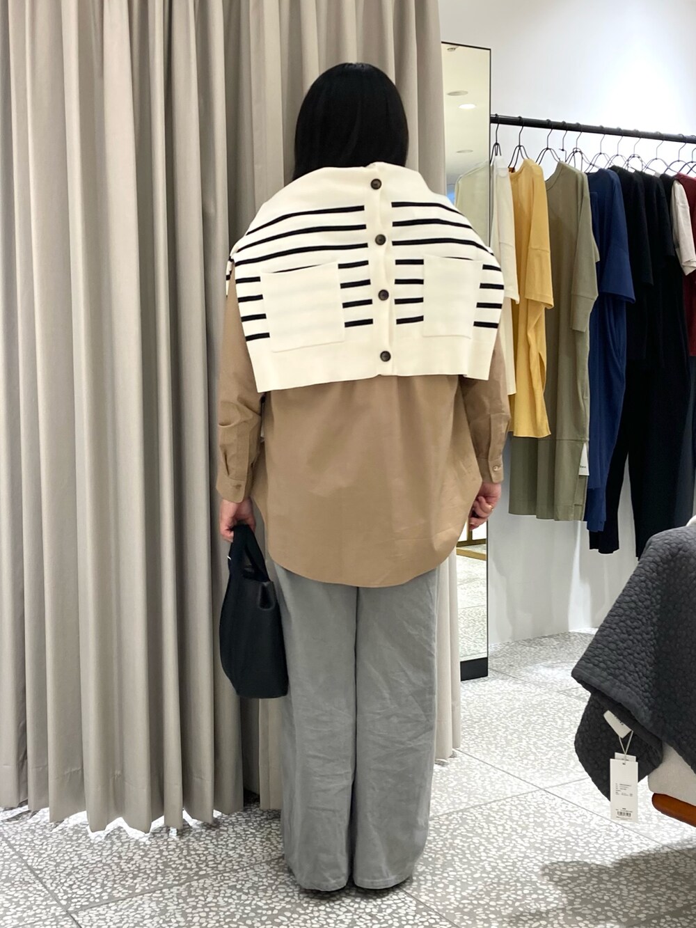 ホワイト系のカーディガン/ボレロ、ベージュ系のシャツ/ブラウス、ブラック系のトートバッグを着用したレディースの秋コーディネートの4枚目の写真