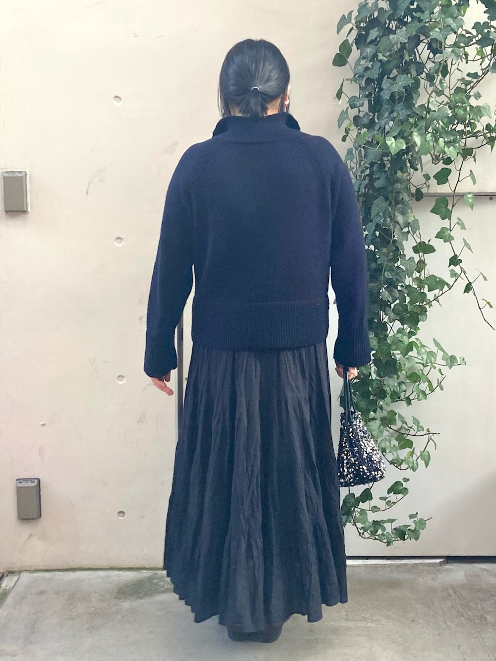 ブルー系のニット/セーター、シルバー系のショルダーバッグ、シルバー系のネックレスを着用したレディースの冬コーディネートの3枚目の写真